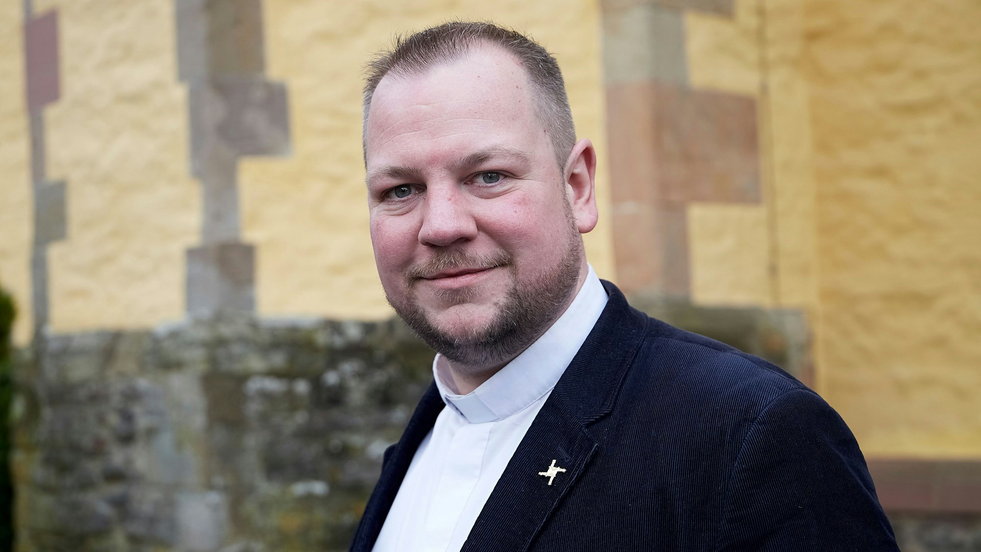 Pfarrer Thomas Schlütter steht vor der Schlosskirche in Schleiden.