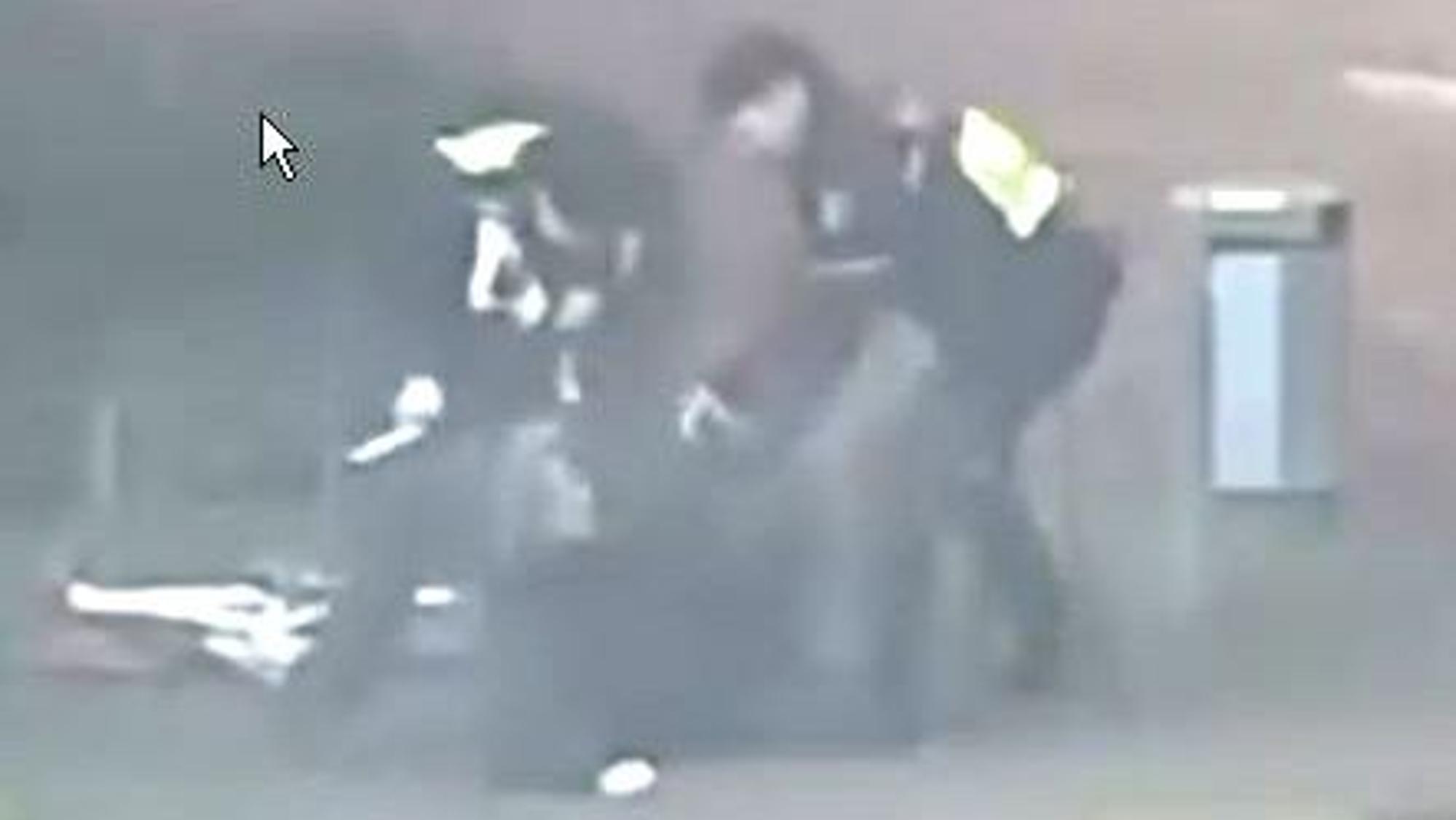 Das Bild ist ein Ausschnitt aus einer Videoaufnahme und zeigt zwei Polizisten, die auf eine Person einschlagen.