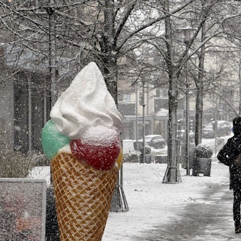 Ein großes, eingeschneites Eishörnchen in einer Fußgängerzone.