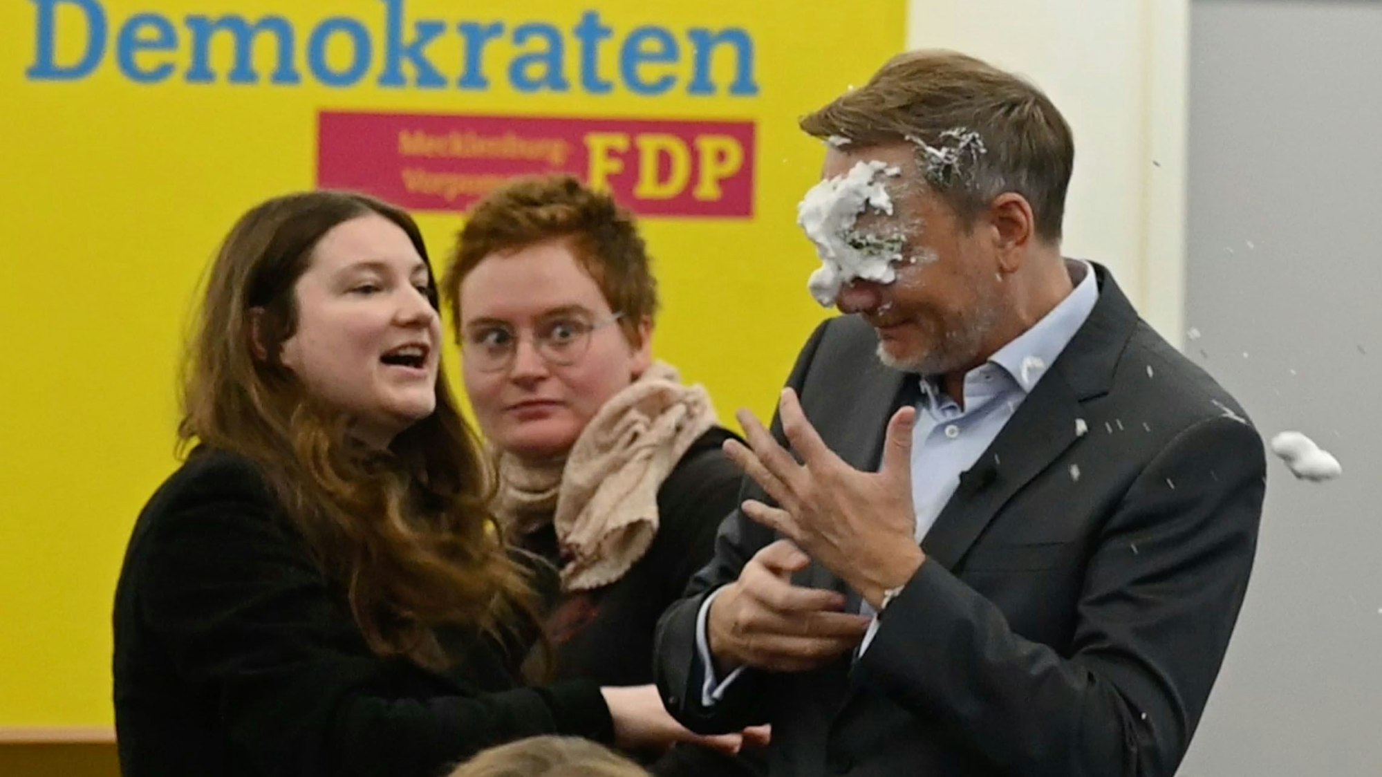 Der FDP-Vorsitzende Christian Lindner (M) bekommt bei einem Wahlkampfauftritt in Greifswald Schaum ins Gesicht. Er war von einer jungen Frau mit Schaum beworfen worden. Sie traf den früheren Finanzminister dabei direkt ins Gesicht. Nach dem Vorfall setzte er seine Rede fort. (Screenshot aus einem Video, Recrop). Foto: Stefan Sauer/dpa +++ dpa-Bildfunk +++
