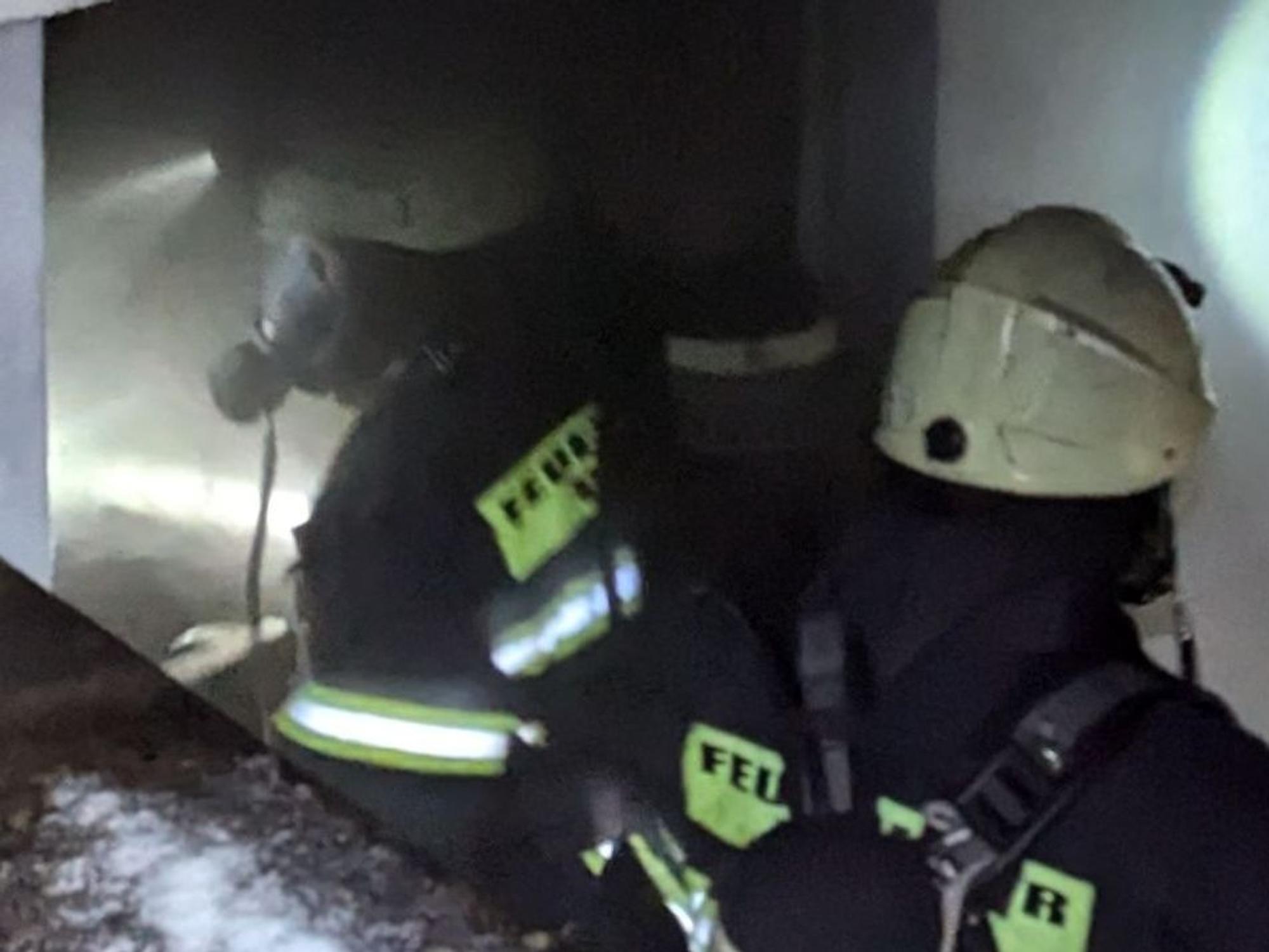 Das Bild zeigt zwei Feuerwehrkräfte mit Atemschutzmasken.