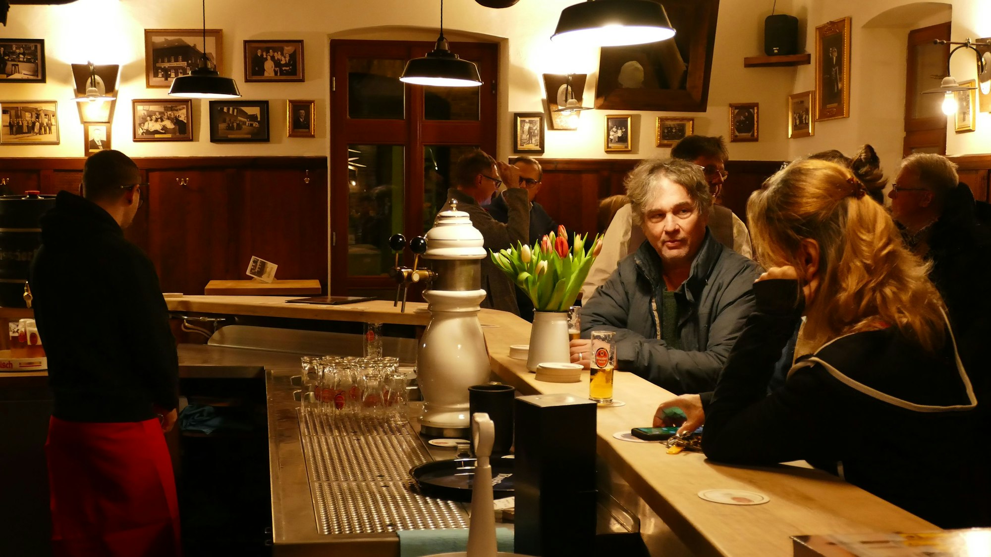 Menschen sitzen an einem Tresen.
