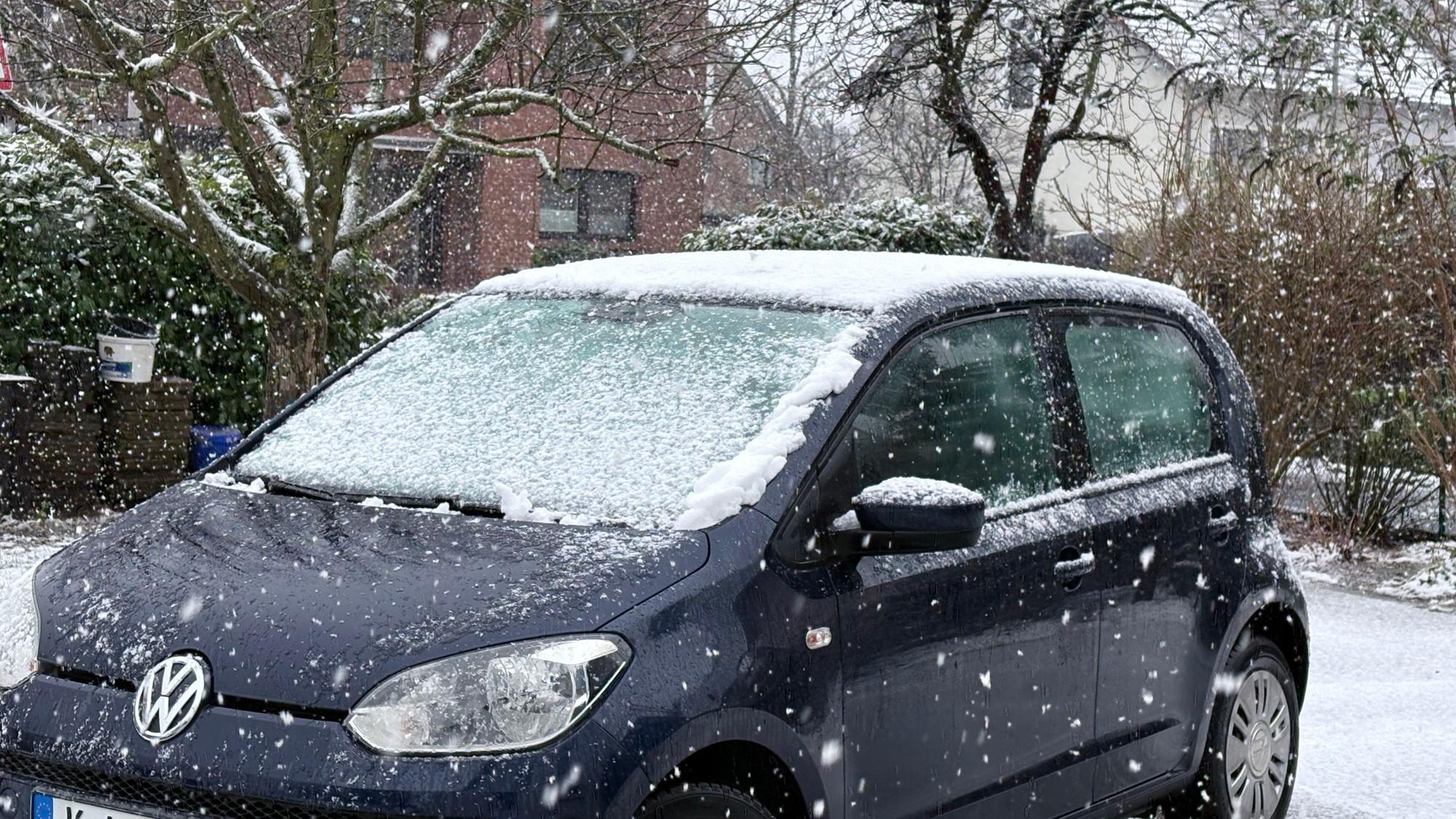 Ein Auto steht in Köln im Schnee.