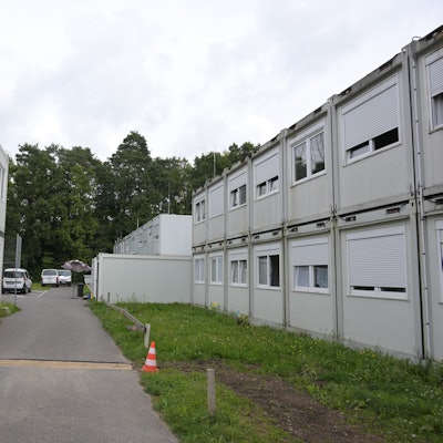 Zwischen zwei zweistöckigen Containerblöcken führt ein Weg.