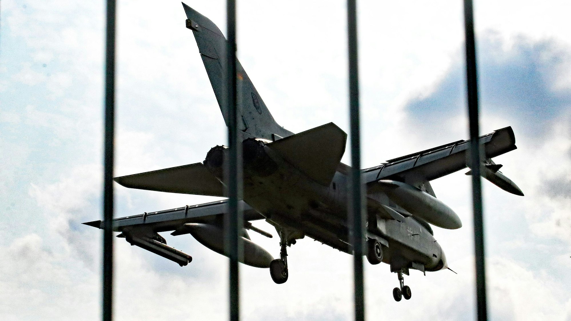 Das Foto zeigt ein Militärflugzeug hinter einem Zaun.