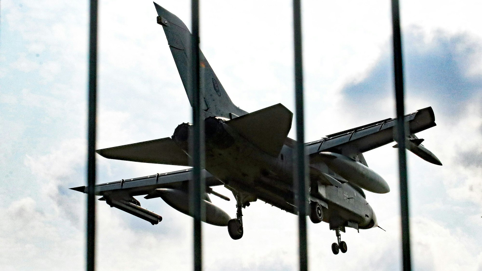 Das Foto zeigt ein Militärflugzeug hinter einem Zaun.