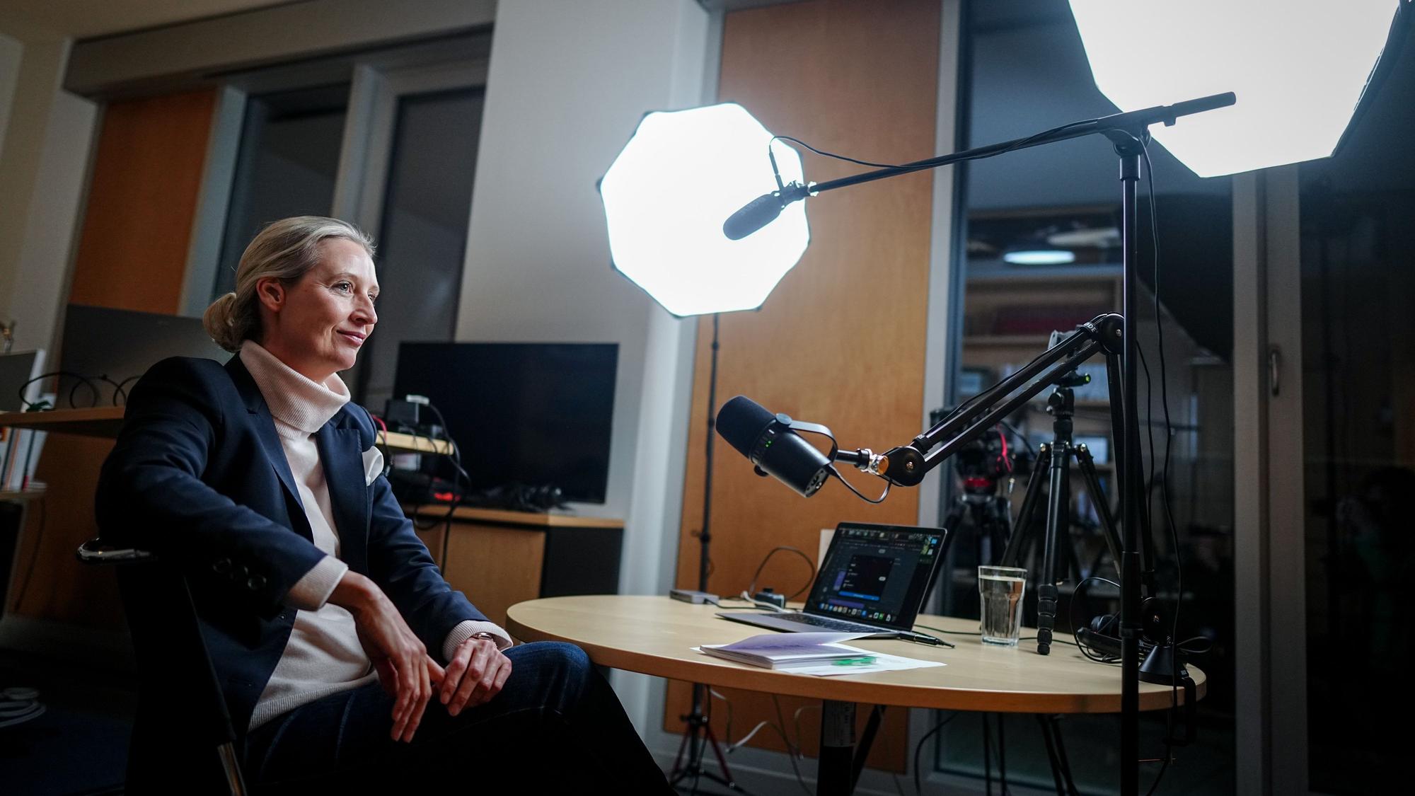 Alice Weidel, Fraktionsvorsitzende, Parteivorsitzende und Kanzlerkandidatin der AfD, sitzt vor dem Live-Talk mit dem US-Milliardär Elon Musk auf der Plattform X an Mikrofonen und einem Laptop in ihrem Büro des Jakob-Kaiser-Hauses.