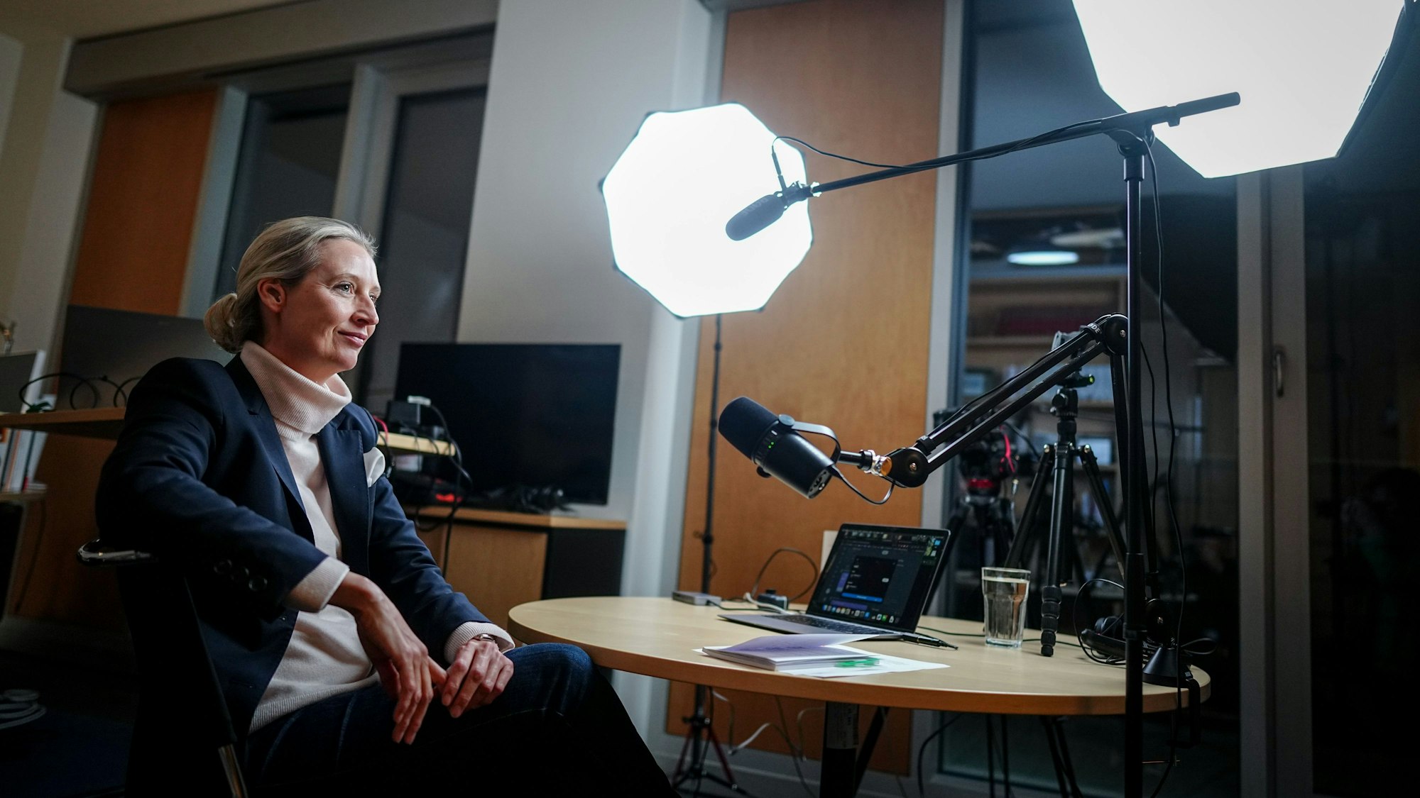 Alice Weidel, Fraktionsvorsitzende, Parteivorsitzende und Kanzlerkandidatin der AfD, sitzt vor dem Live-Talk mit dem US-Milliardär Elon Musk auf der Plattform X an Mikrofonen und einem Laptop in ihrem Büro des Jakob-Kaiser-Hauses.