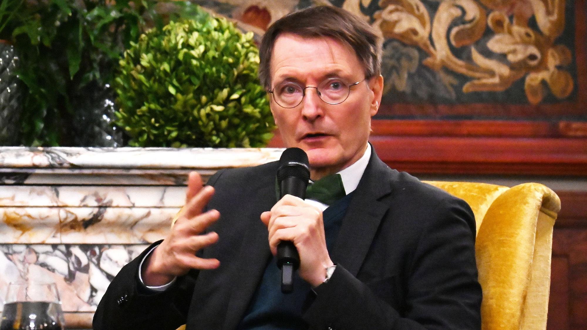 Zu sehen ist Karl Lauterbach, der in ein Mikrofon spricht.