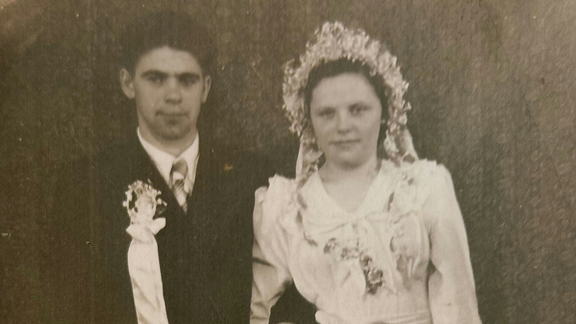 Schwarzweiß-Foto eines jungen Hochzeitspaars.