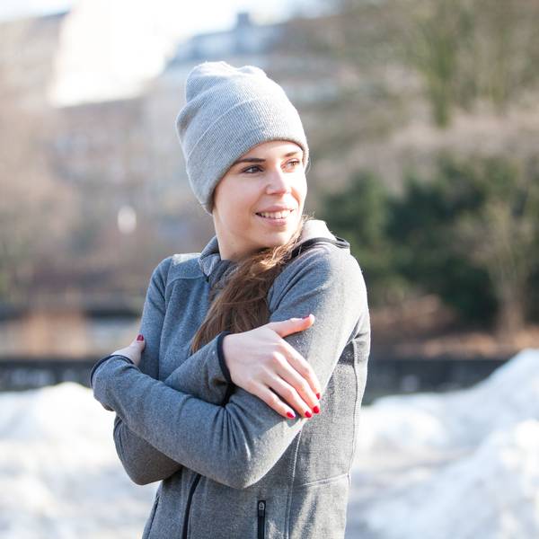 Frau in einem winterlichen Park friert