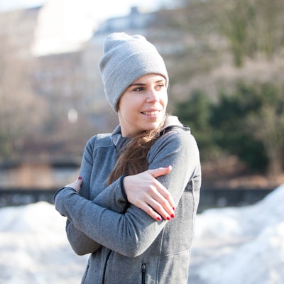 Frau in einem winterlichen Park friert