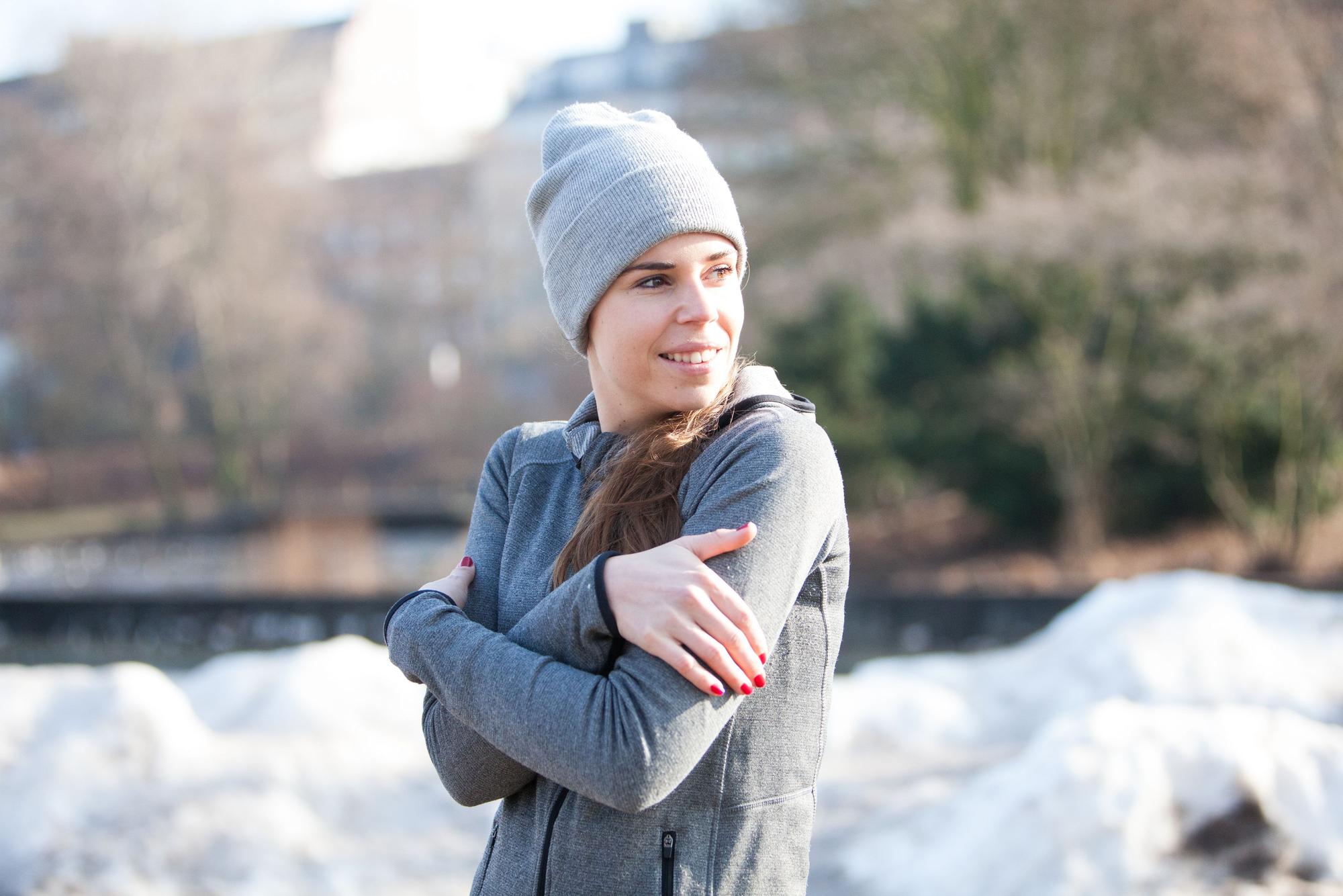 Frau in einem winterlichen Park friert