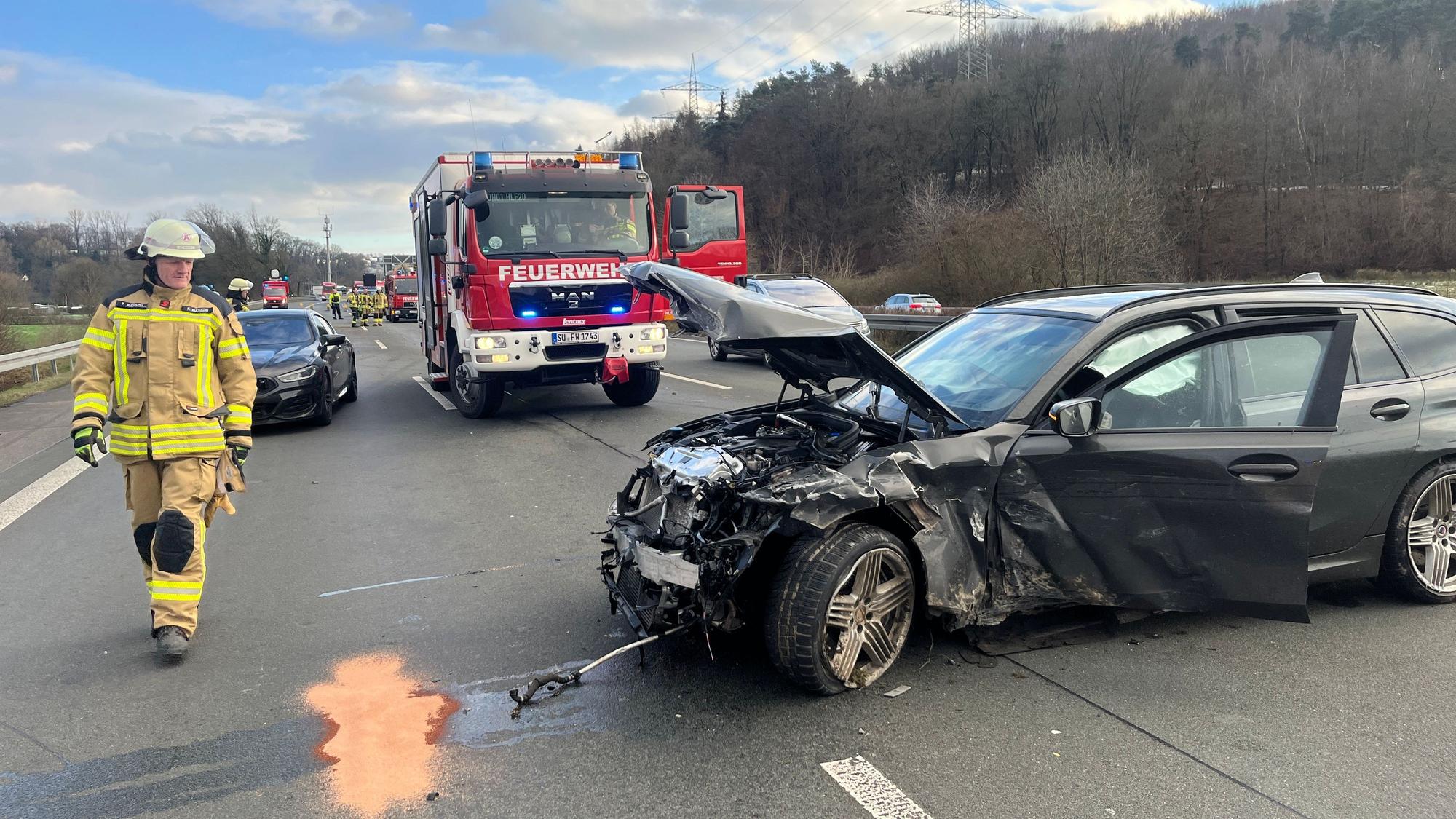 Ein schwer beschädigtes Auto steht quer zur Fahrtrichtung auf der Autobahn.