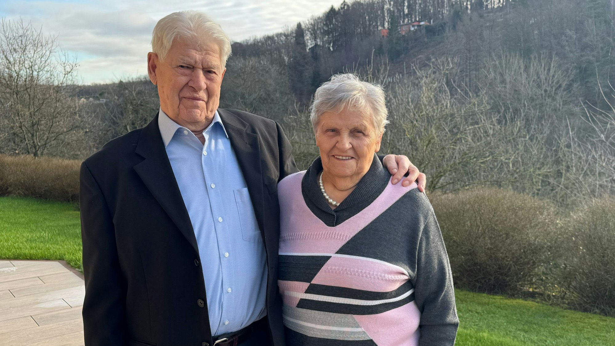 Ein älteres Ehepaar posiert im Garten.