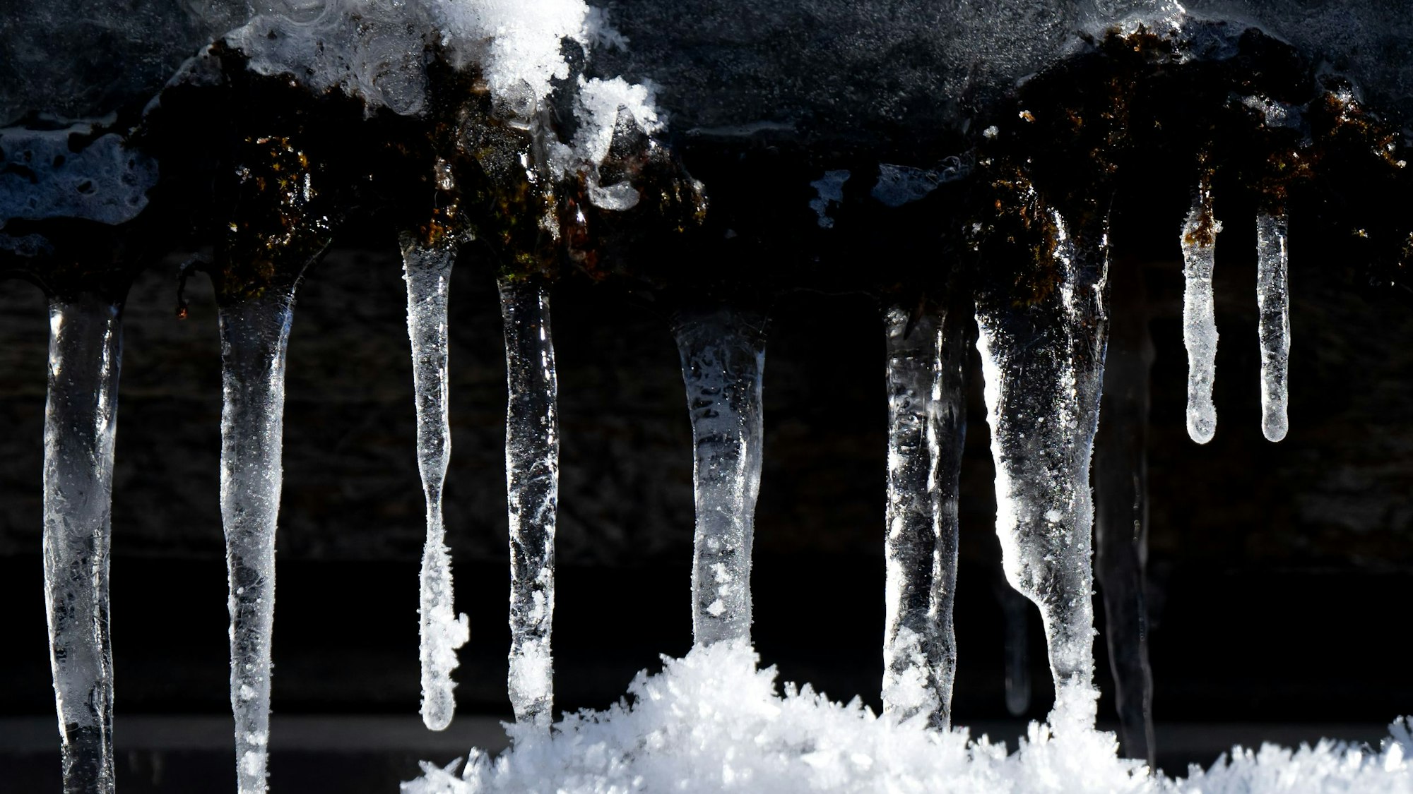 29.12.2024, Bayern, Kreuth: Eiszapfen hängen in der Sonne an einer Hütte. Foto: Sven Hoppe/dpa +++ dpa-Bildfunk +++
