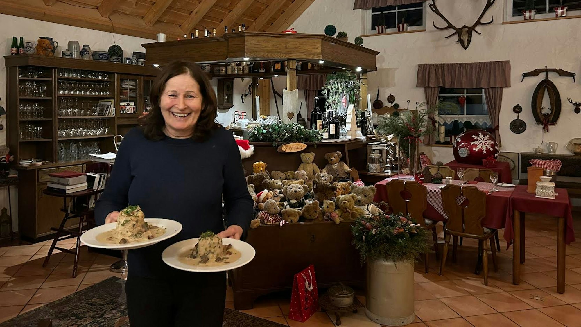 Inge Schmuck vom Burscheider „Schmuck Kastl mit zwei Tellern auf dem Arm.