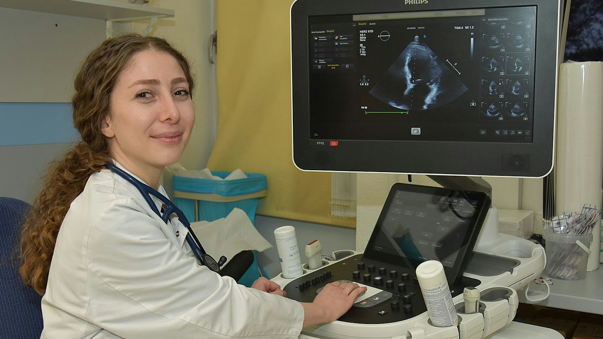 Zu sehen ist eine junge syrische Ärztin an einem medizinischen Apparat.