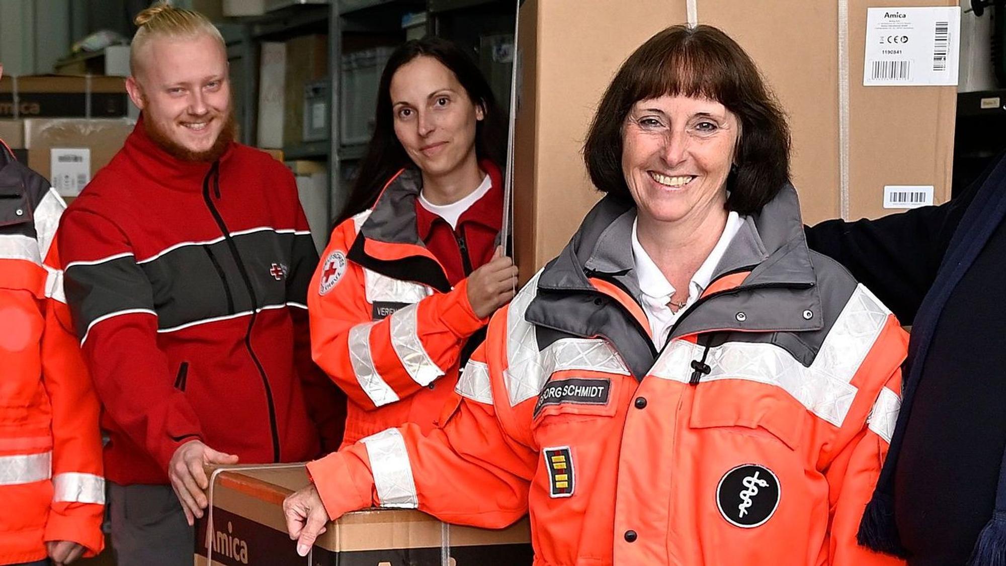 Ingeborg Schmidt, mit ihrer Tochter Verena Stentenbach und einem weiteren DRK-Mitarbeiter bei der Übernahme für Spenden für Flutopfer.