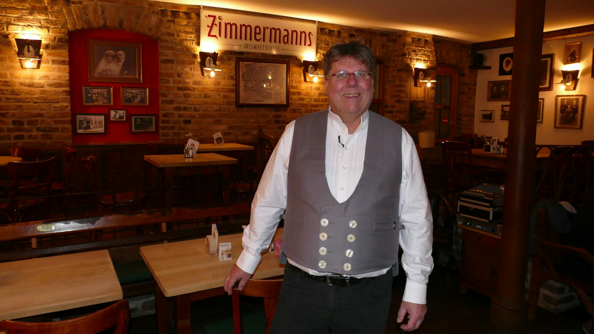 Ein Mann zapft Kölsch aus einem Fass.