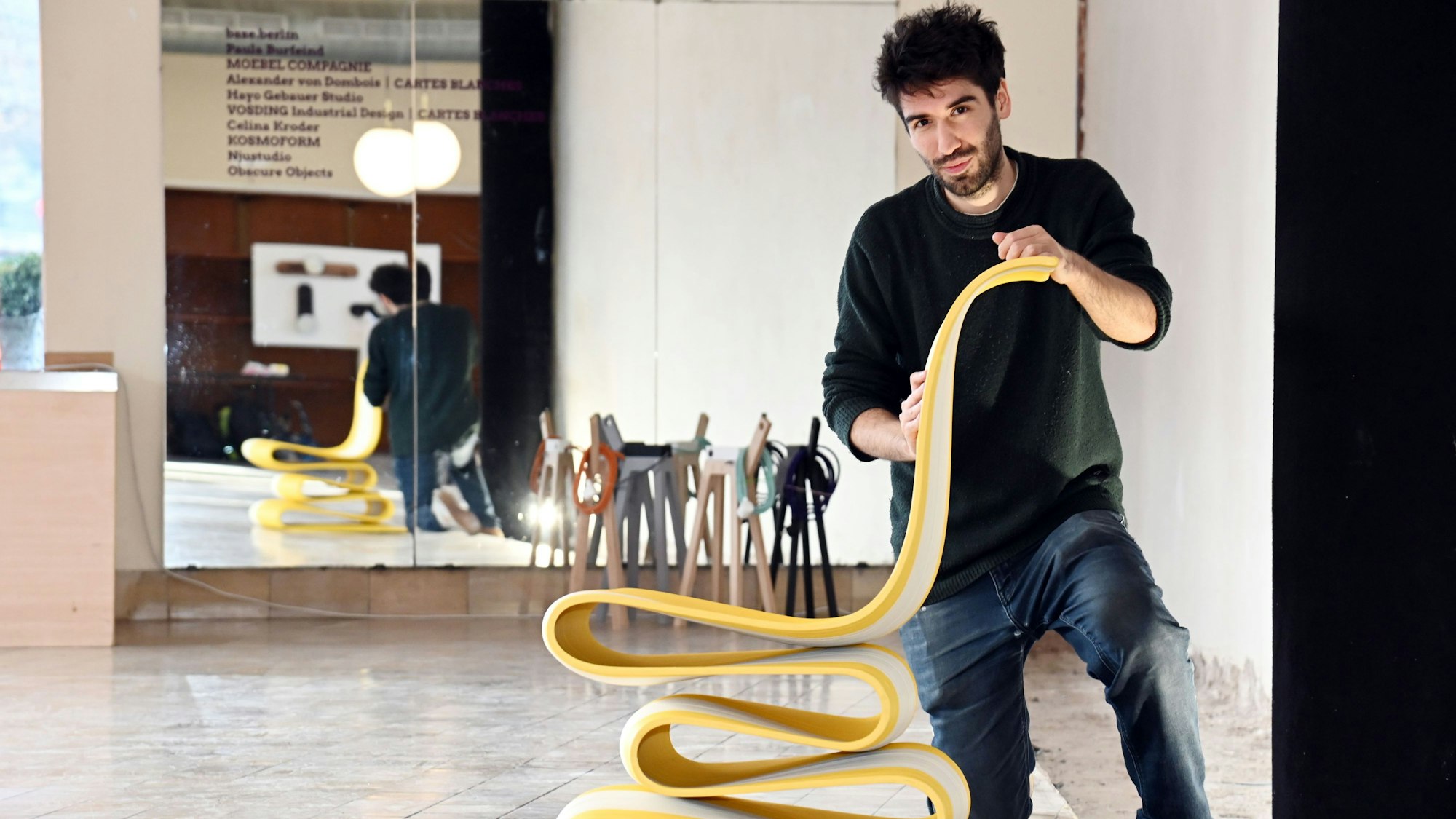 Ein Mann präsentiert seinen Design-Stuhl.