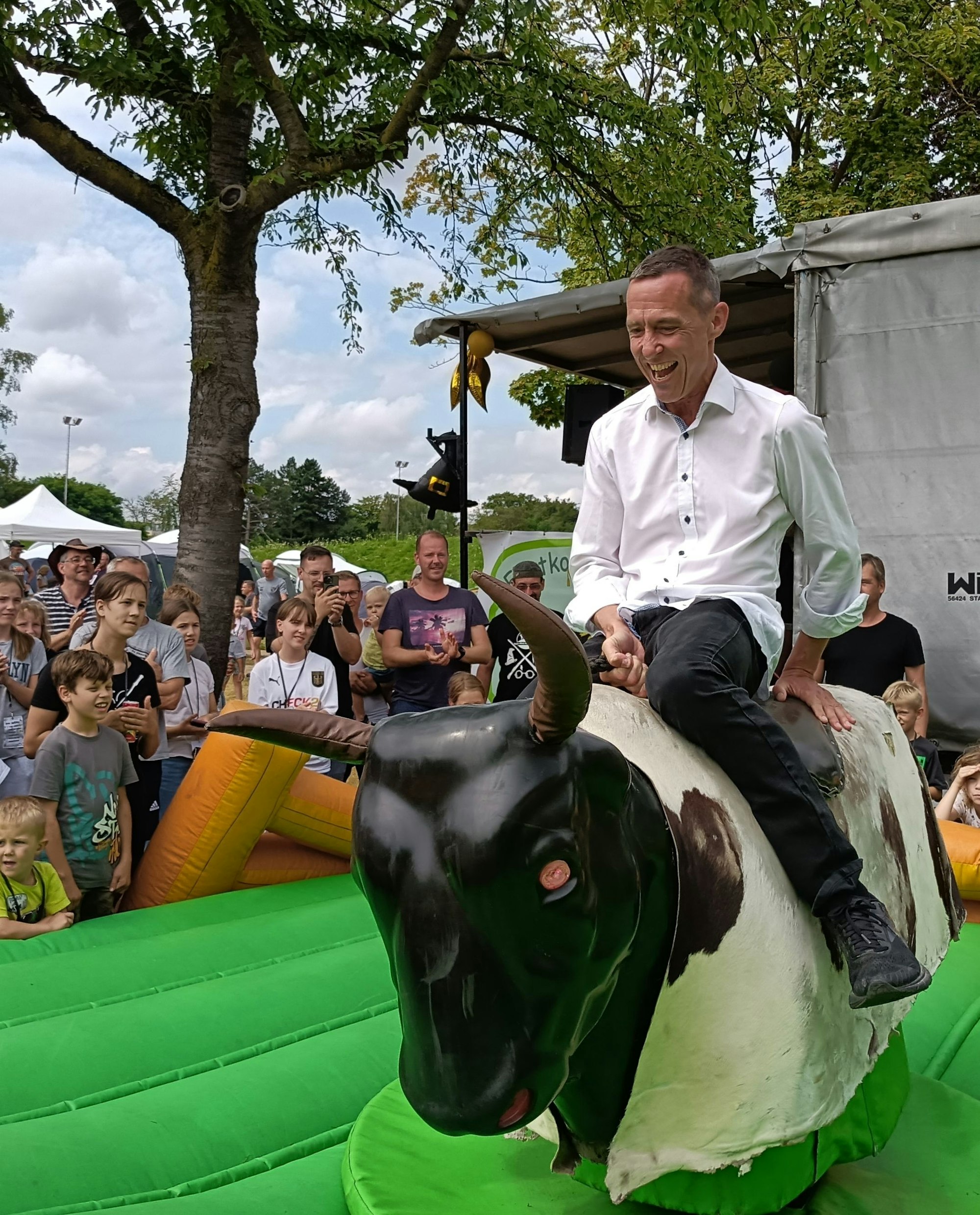 Auf dem Foto ist ein Mann auf einem elektrischen Bullen zu sehen.