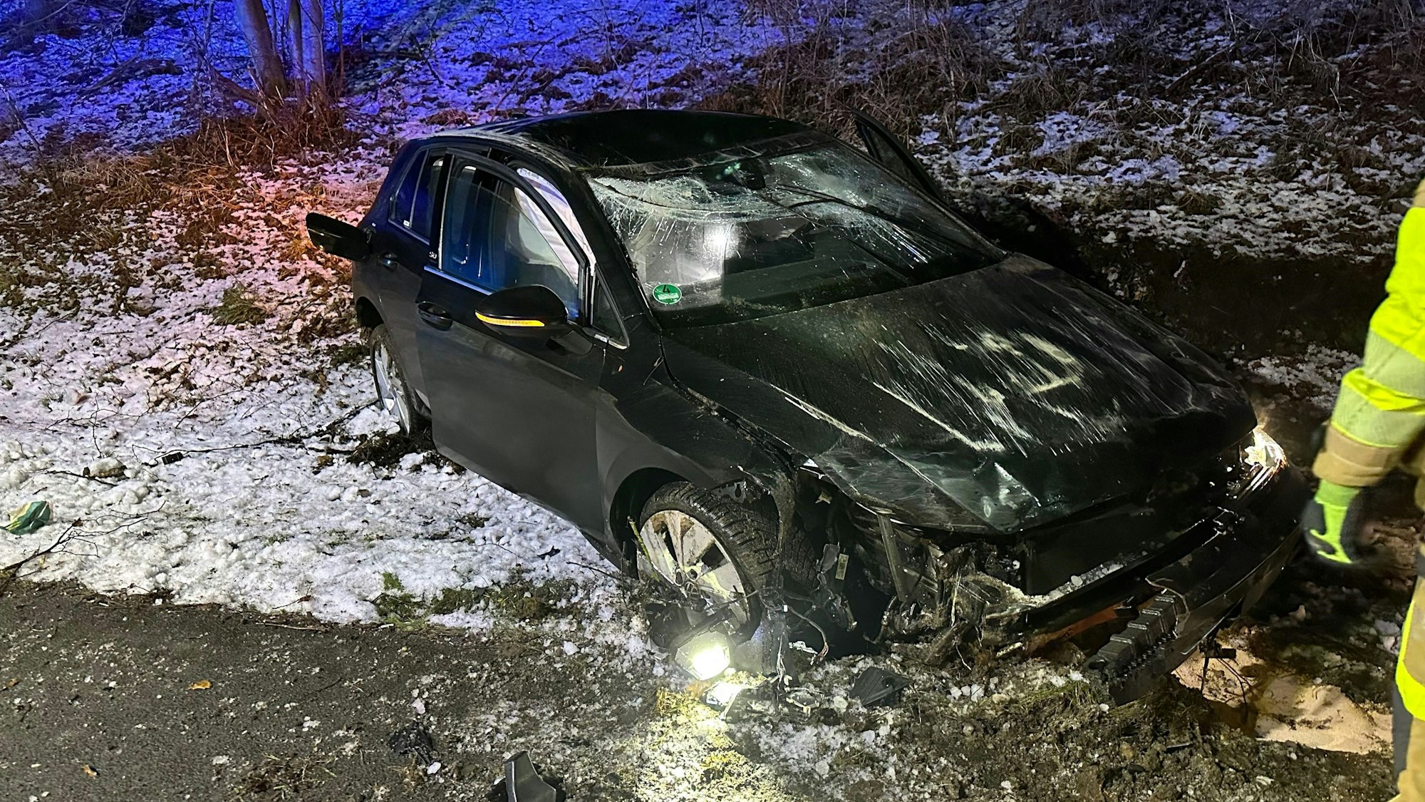 Ein zerstörtes Auto steht an der A61 in einem Graben.