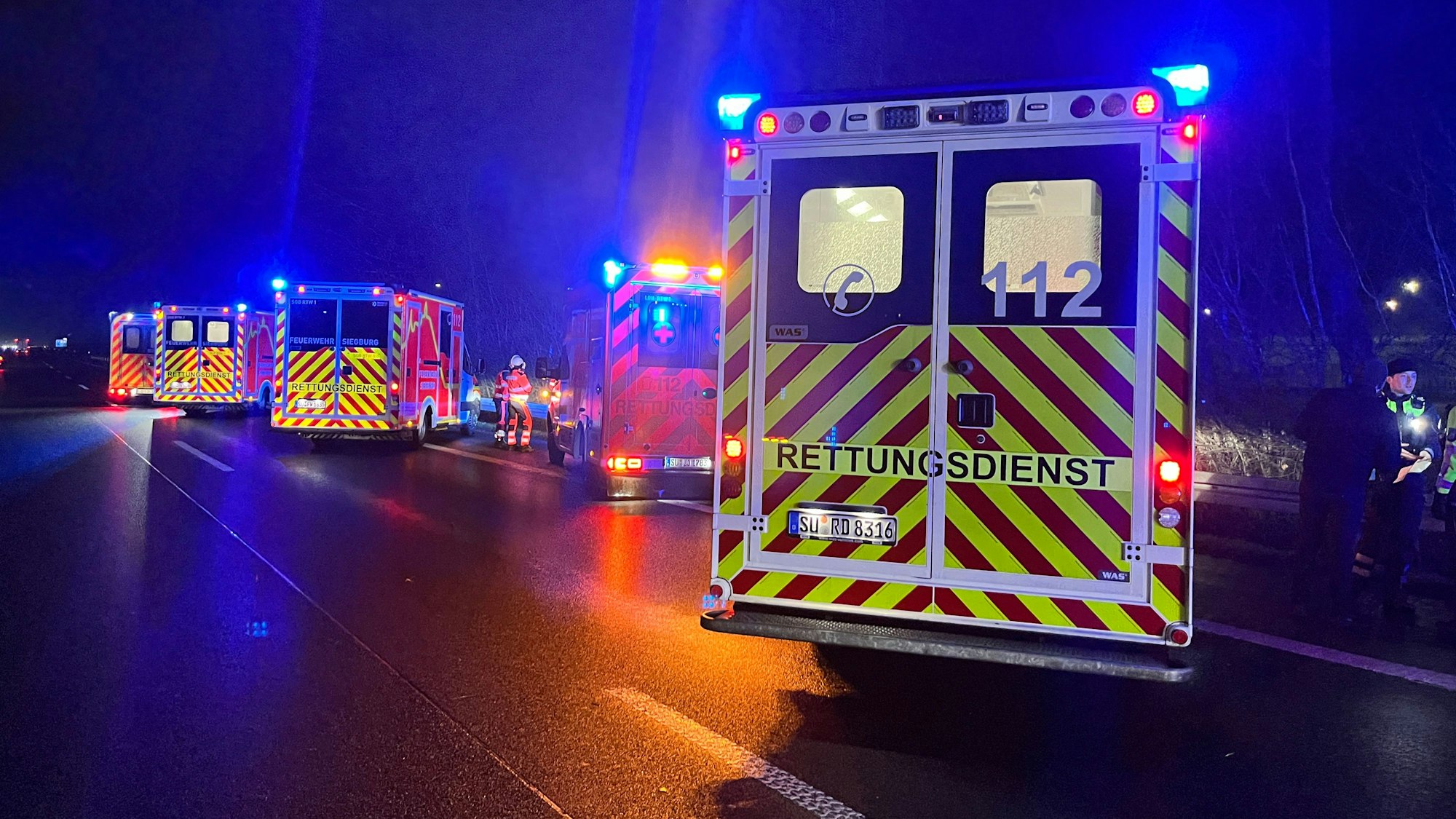 Fünf Rettungswagen stehen auf einer Autobahn.