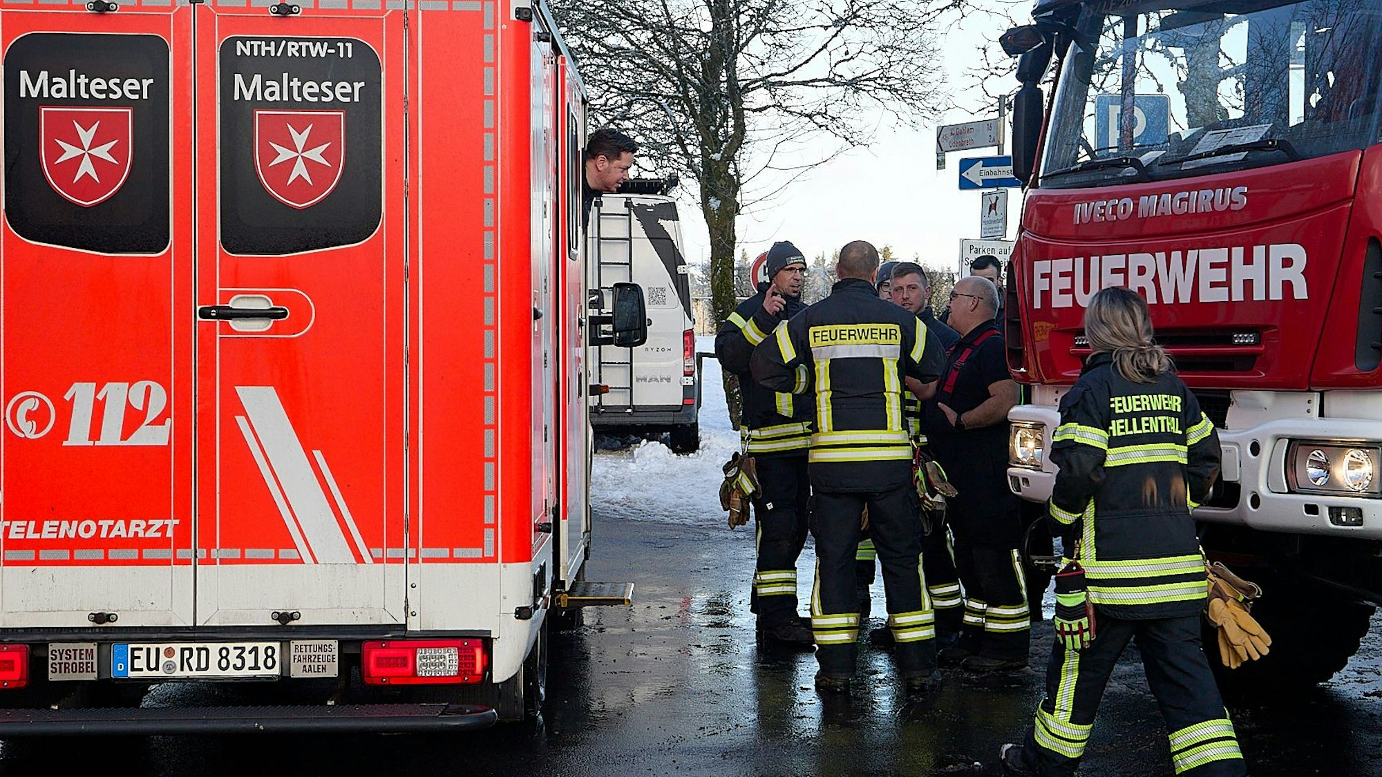 Links steht ein Rettungswagen der Malteser, rechts daneben einige Feuerwehrleute und ein großes Löschfahrzeug.