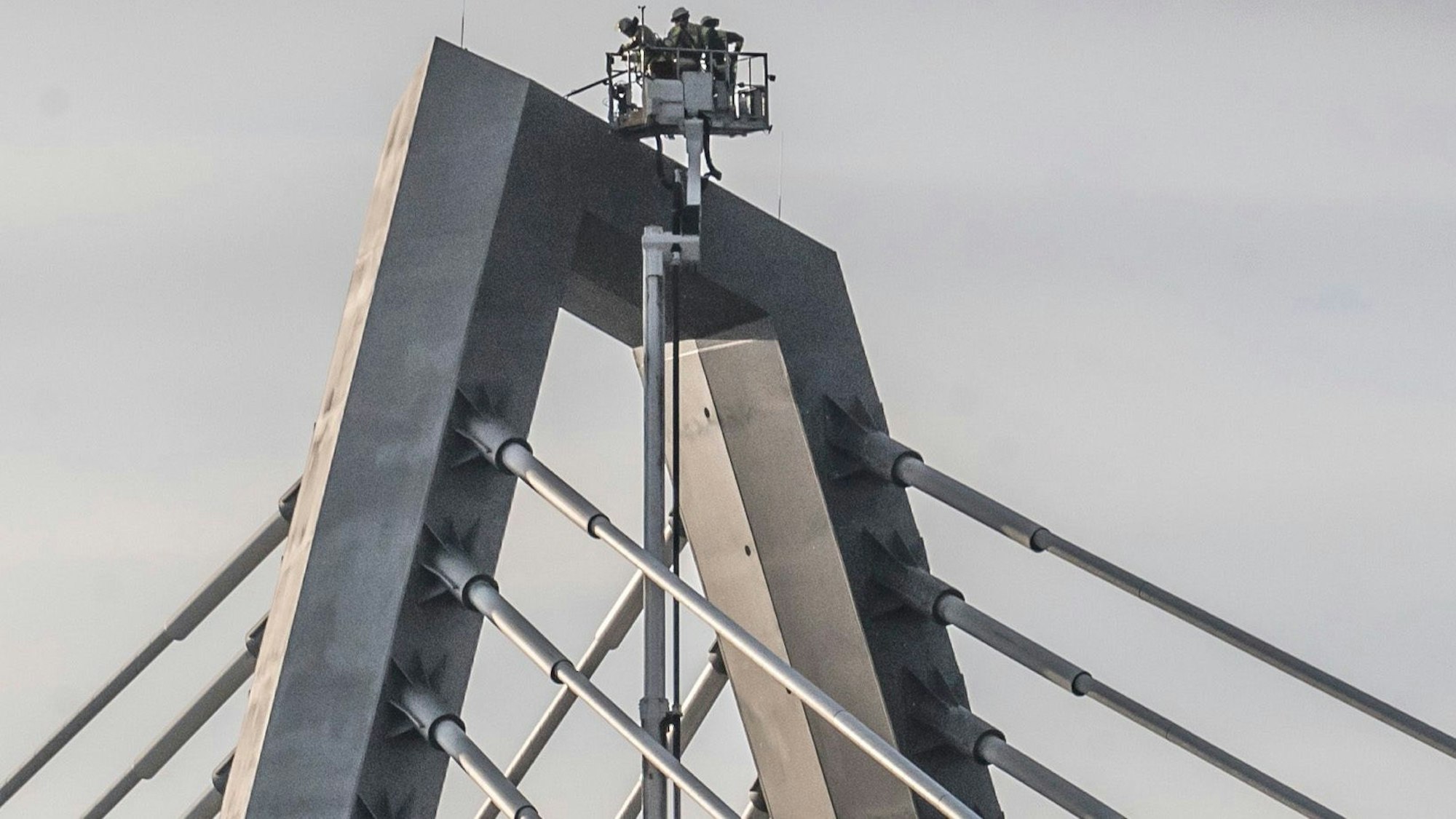 Drei Feuerwehrmänner ließen sich mit einem Hubsteiger 55 Meter hoch zu den Schneefeldern hieven, um die Gefahr mit einem Besen abzukehren.