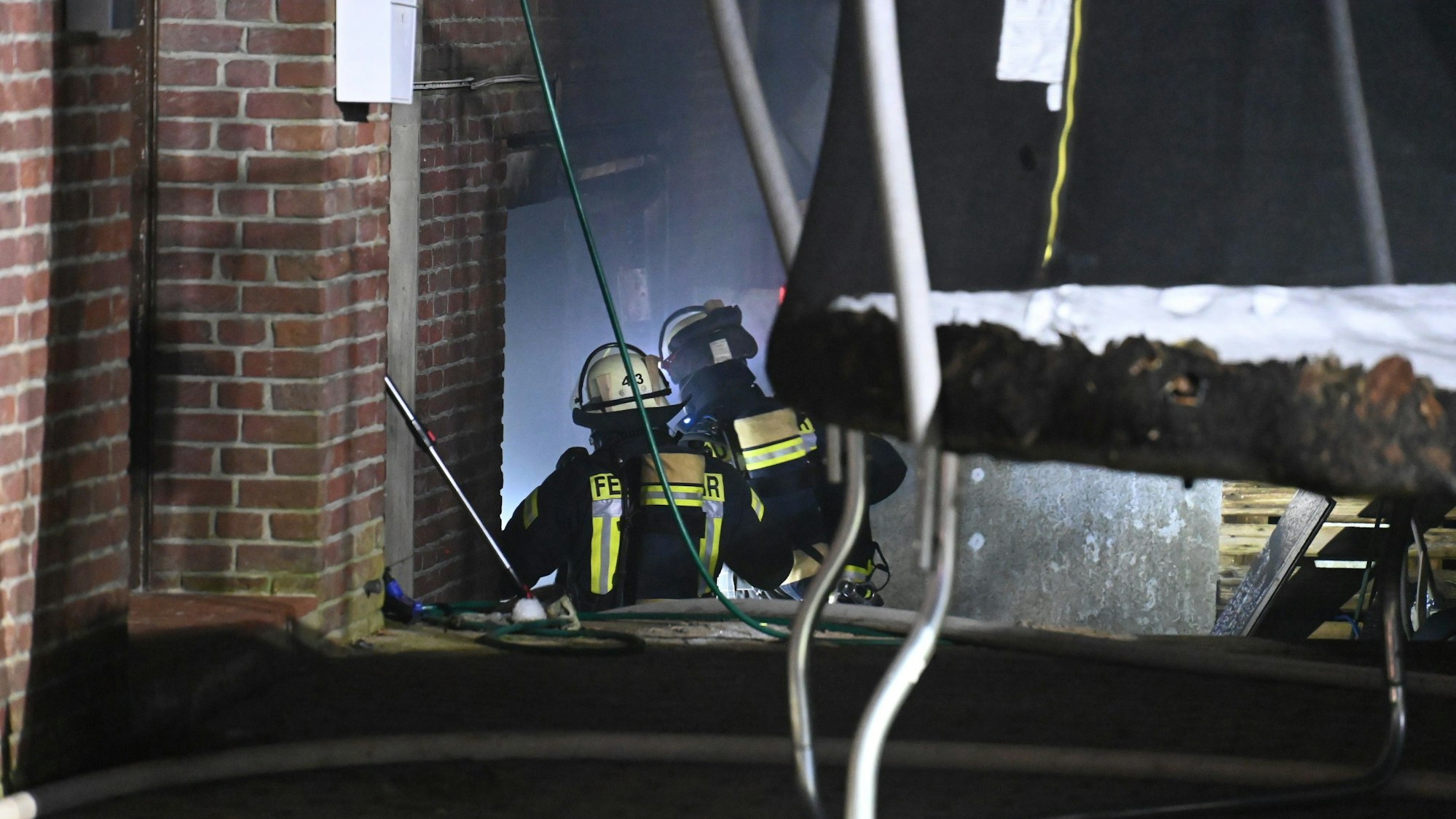 Feuerwehrleute betreten das Gebäude, nachdem sie es gelöscht hatten.