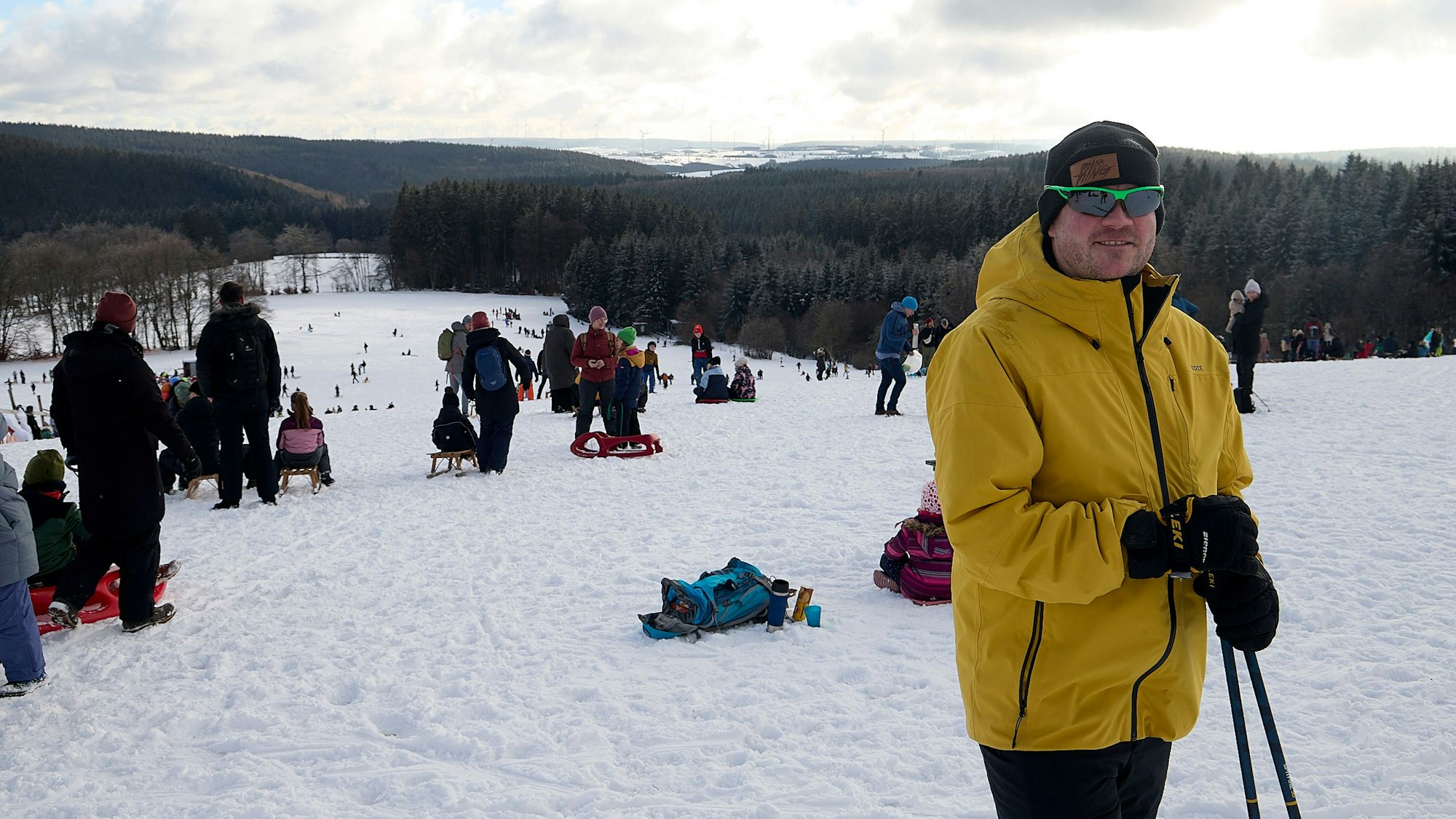 Der Skilehrer Tobias Gravenstein aus Kerpen trägt eine gelbe Jacke und steht auf dem schneebedeckten Weißen Stein in Hellenthal-Udenbreth.