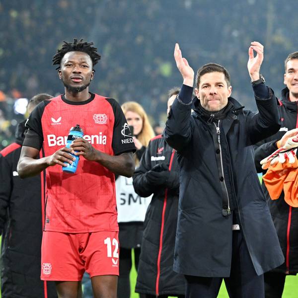 Leverkusens Edmond Tapsoba (l-r), Trainer Xabi Alonso und Jonathan Tah feiern den Sieg in Dortmund.
