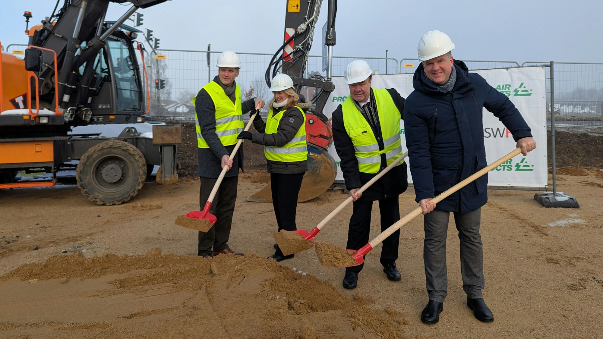 Das Foto zeigt die Vertreterinnen und Vertreter von Air Products und der Stadt mit Helm und Spaten auf der Baustelle.