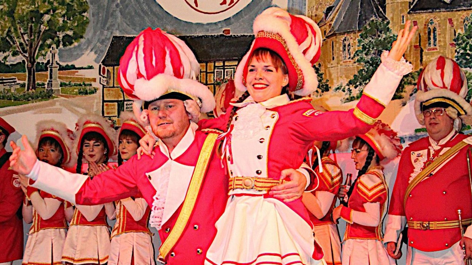 Leonie Pünzeler und Dirk Lamb tragen rot-weiße Gardekostüme. Sie tanzen auf der Bühne in Zülpich-Dürscheven.