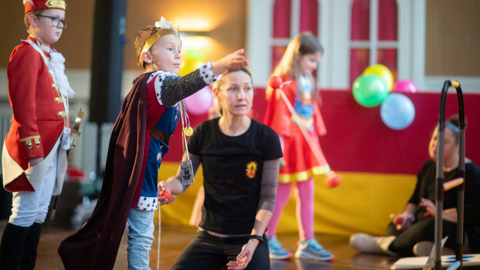 Das Bild zeigt einen Jungen, der versucht, zwei Kugeln, die an einer Schnur befestigt sind, um eine Stange zu werfen.