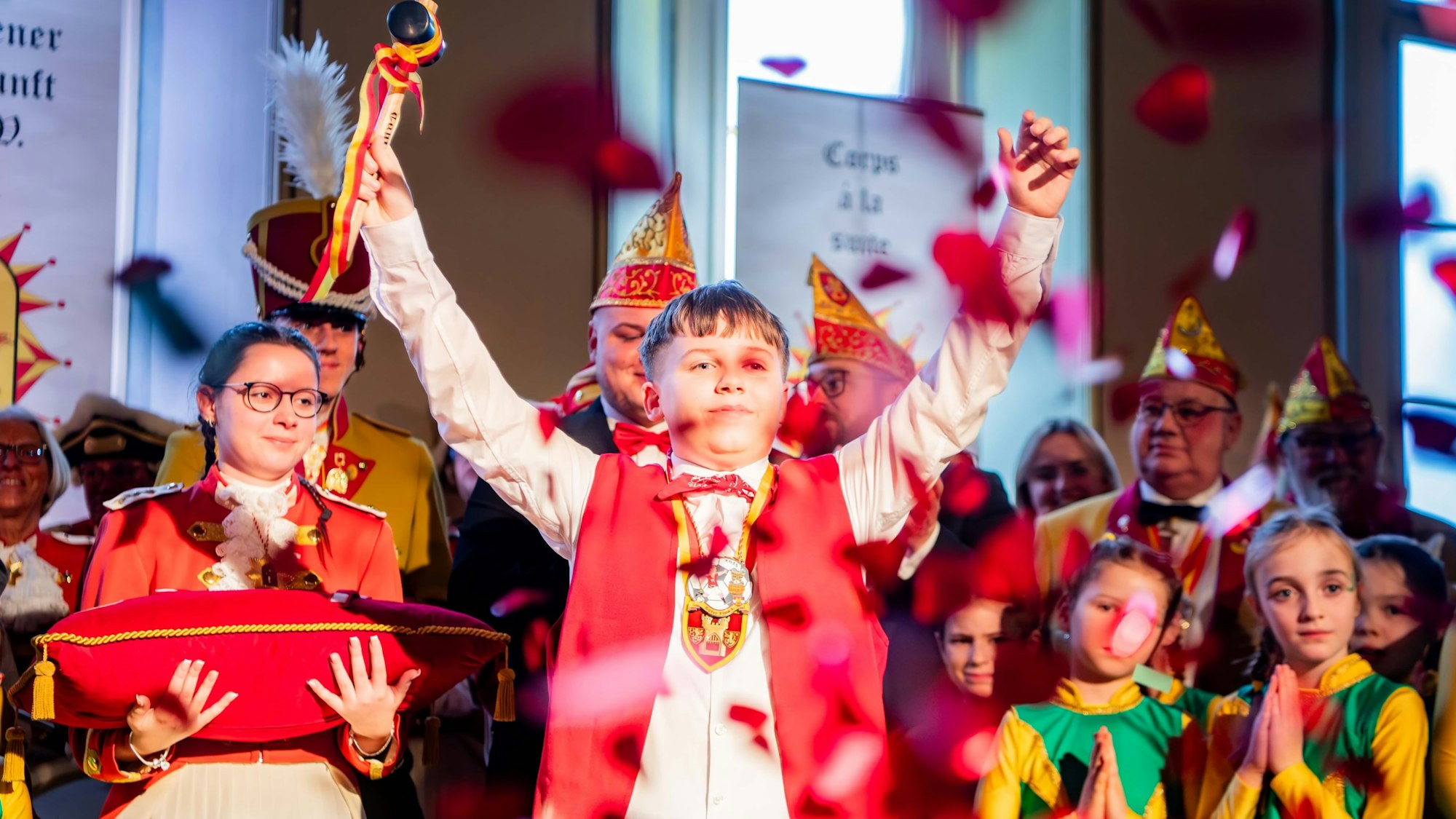 Im Euskirchener Casino steht Küfer Finn I. (Wassong) als Küfer mit erhobenen Armen, begleitet von anderen Karnevalisten, auf der Bühne.
