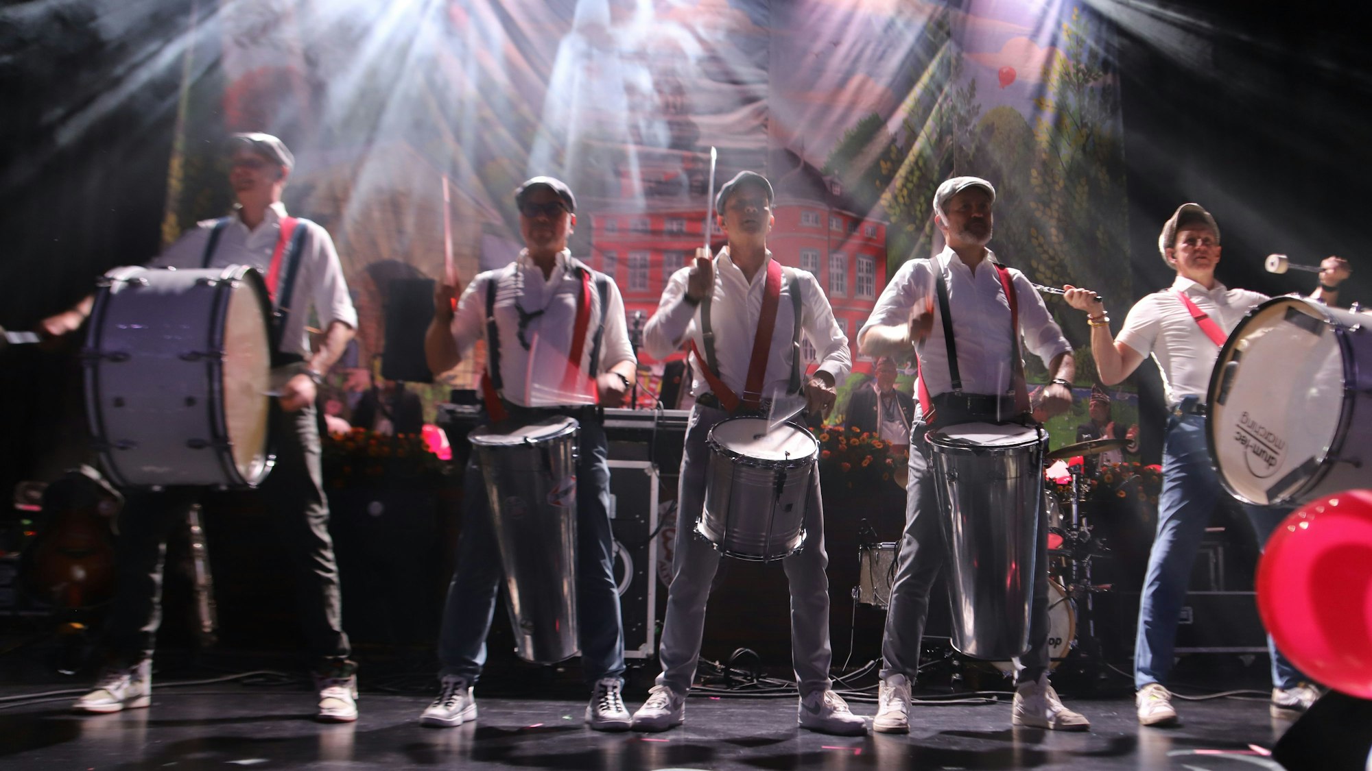 Fünf Musiker schlagen auf ihre Trommeln.