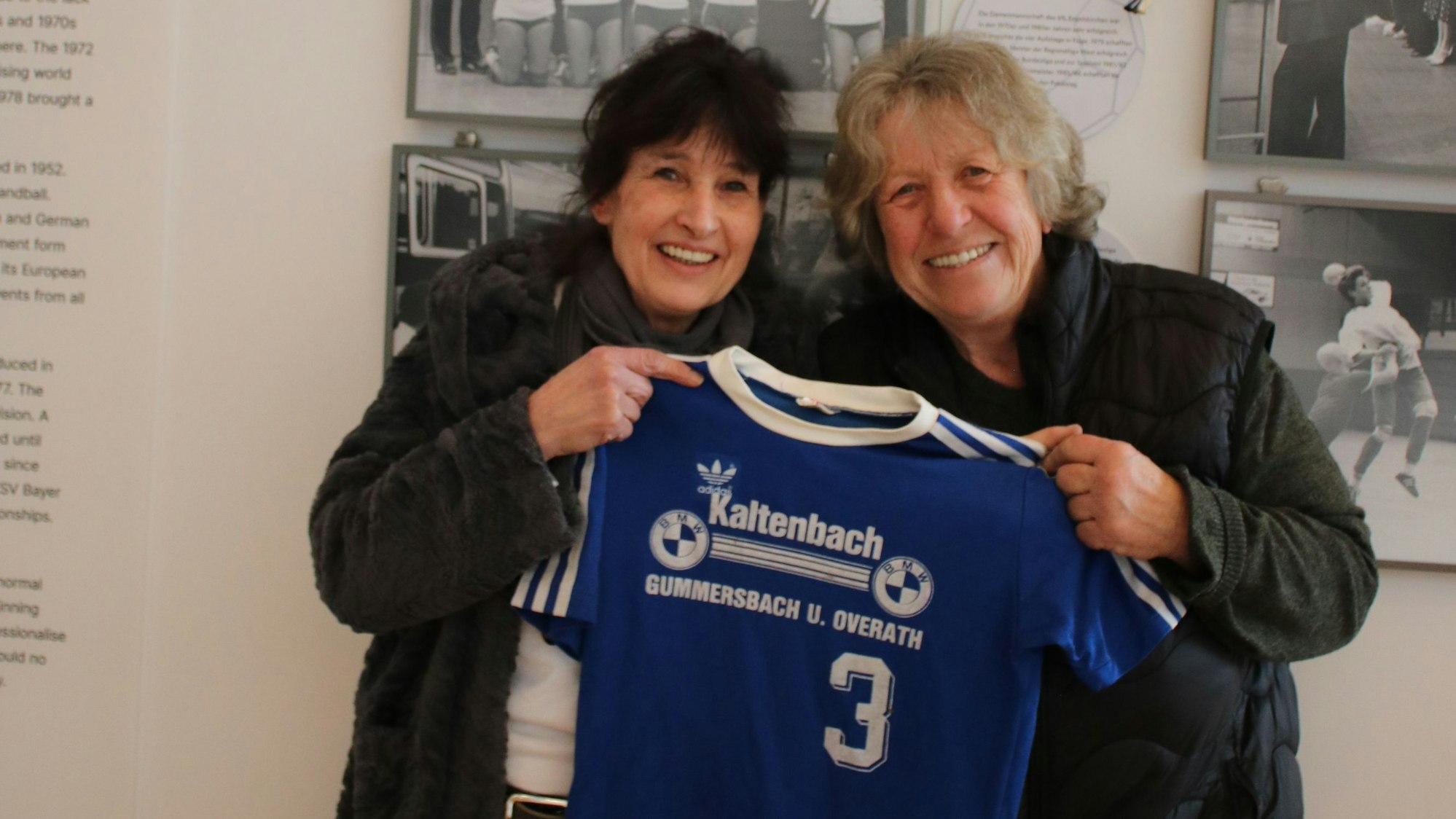 Zwei Frauen halten ein ehemaliges Handball-Aufstiegstrikot des VfL Engelskirchen in den Händen.