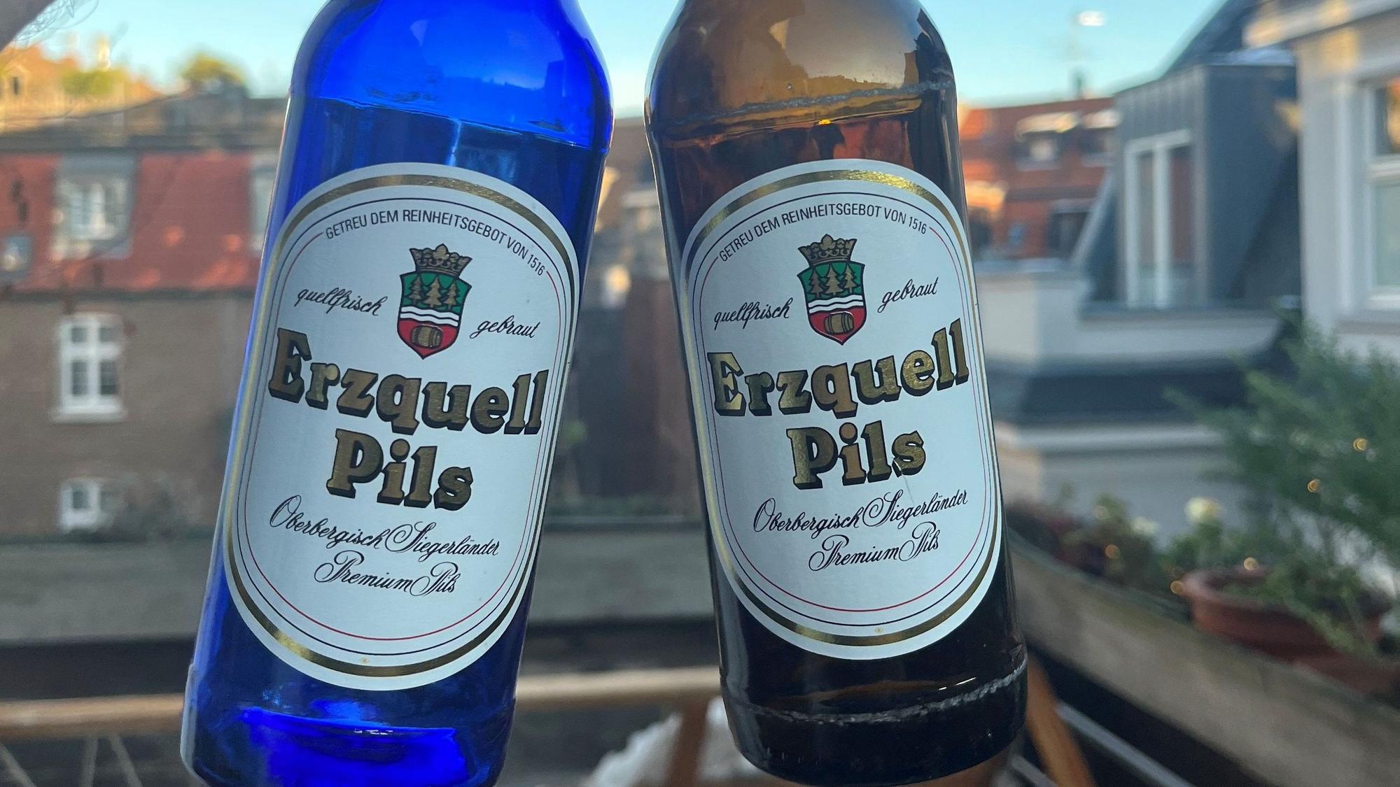 Zwei Flaschen Erzquell Pils, links die sehr seltene blaue, rechts die normale braune Flasche.