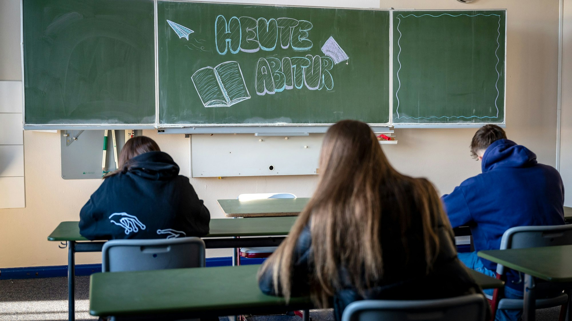 "Heute Abitur" steht auf einer Tafel im Klassenzimmer eines Gymnasiums.