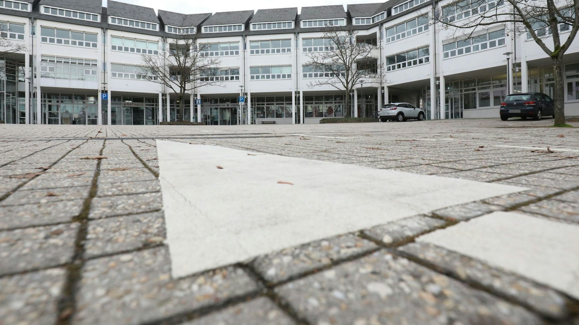 Eine gepflasterte Fläche mit einem großen weißen Pfeil vor dem Rathaus Bad Honnef.