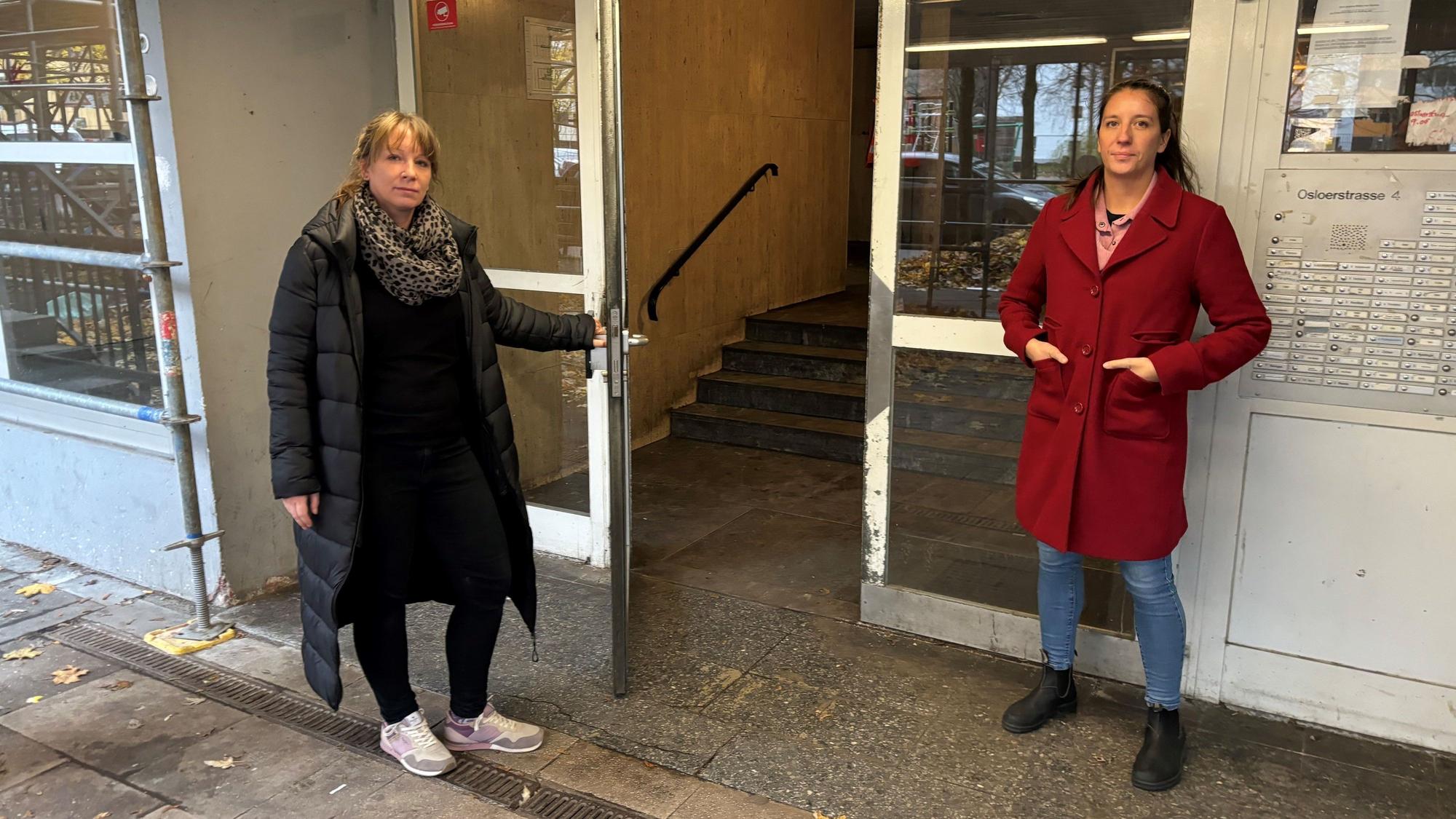 Julia Ecker (l.) und Lena Teschlade (SPD) am Eingang des Haushauses Olsoer Straße in Chorweiler.