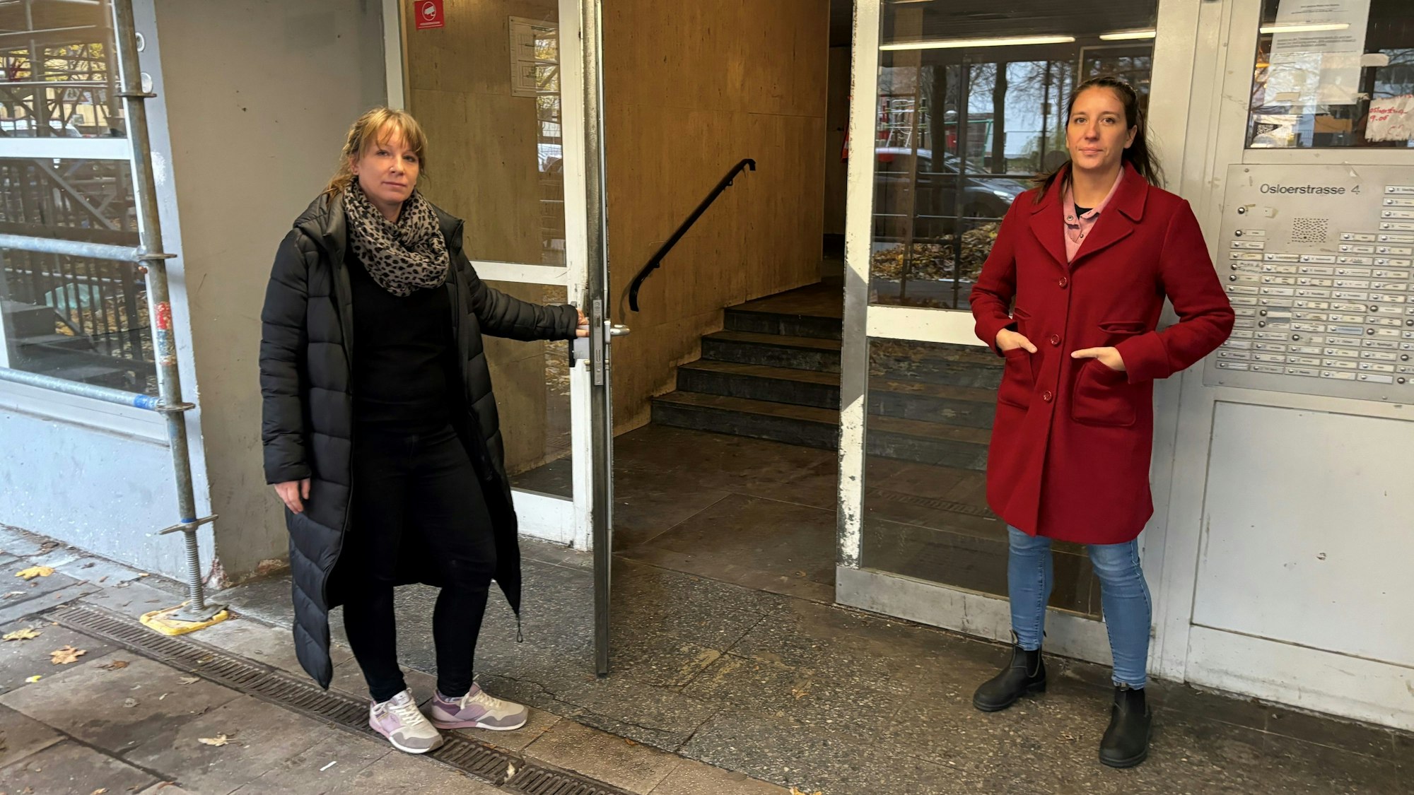 Julia Ecker (l.) und Lena Teschlade (SPD) am Eingang des Haushauses Olsoer Straße in Chorweiler.