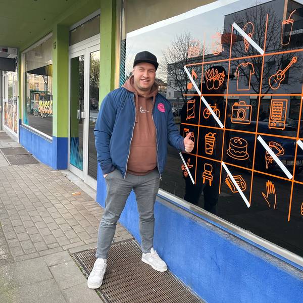 Mann vor Ladenlokal.