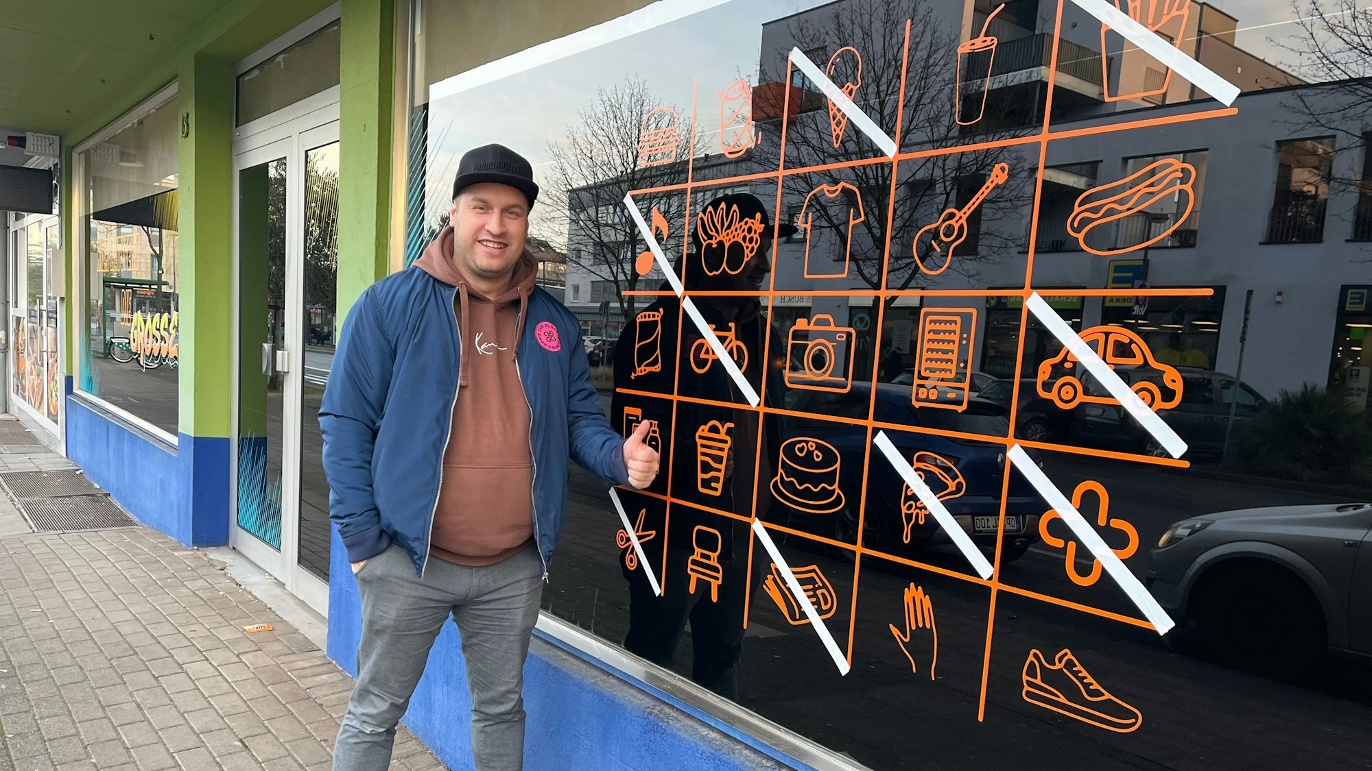 Mann vor Ladenlokal.