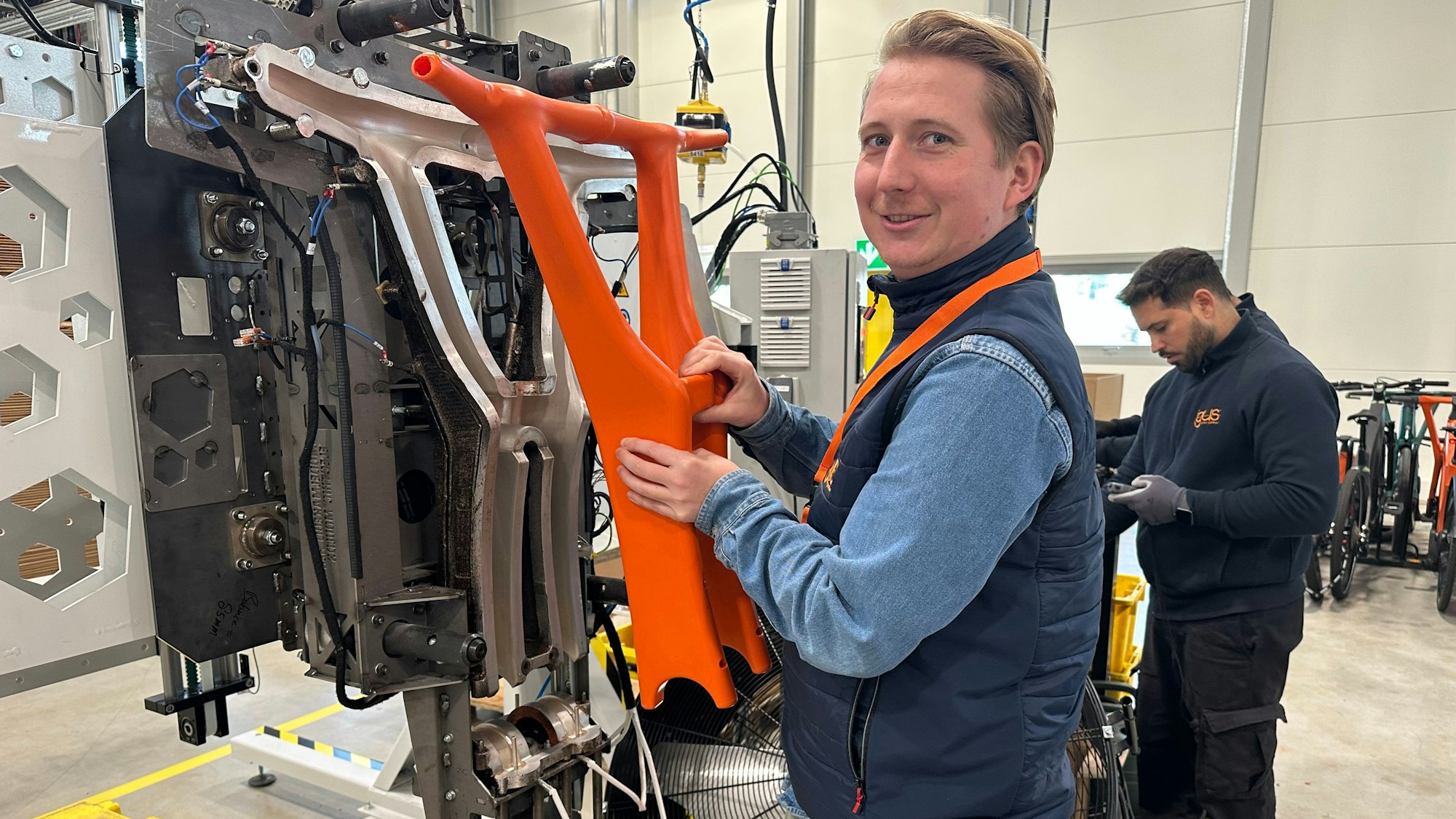 Igus-Fahrradprojektleiter Sven Terhardt zeigt, wo die Kunststoffteile produziert werden.