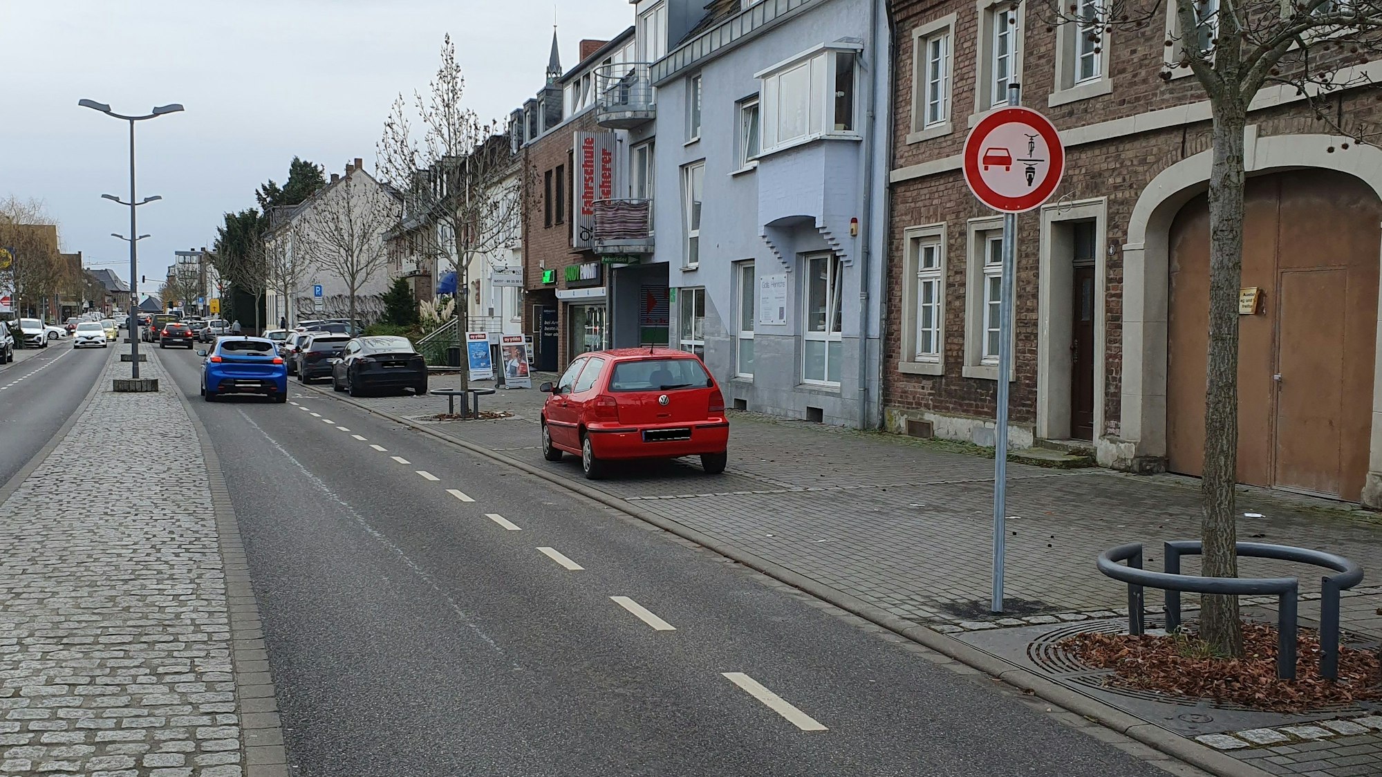 Das Foto zeigt eine Straße mit einem Schild, welches das Überholen von Zweirädern verbietet.