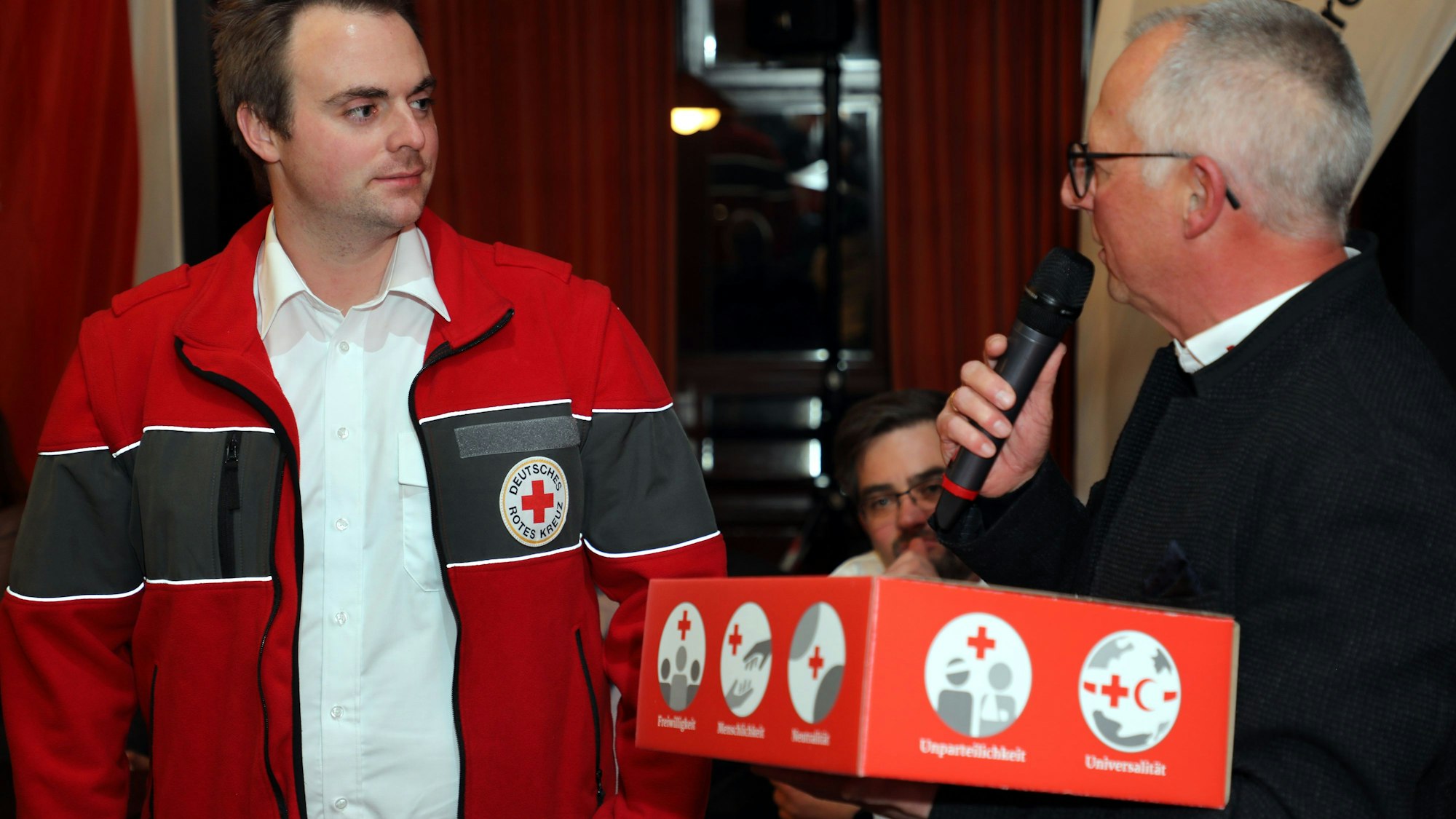 DRK-Kreisgeschäftsführer Reinhold Feistl überreicht Steffen Schmidt ein DRK-Paket.