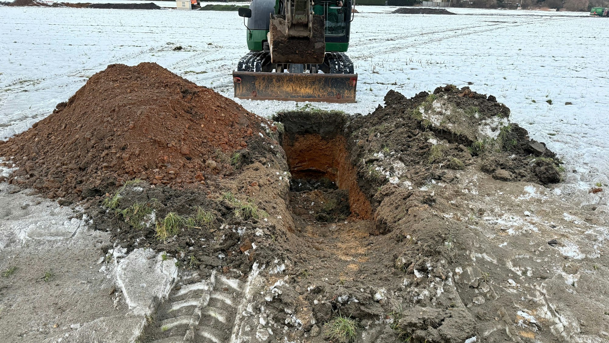 Zu sehen ist ein Bagger, der ein Loch gegraben hat.